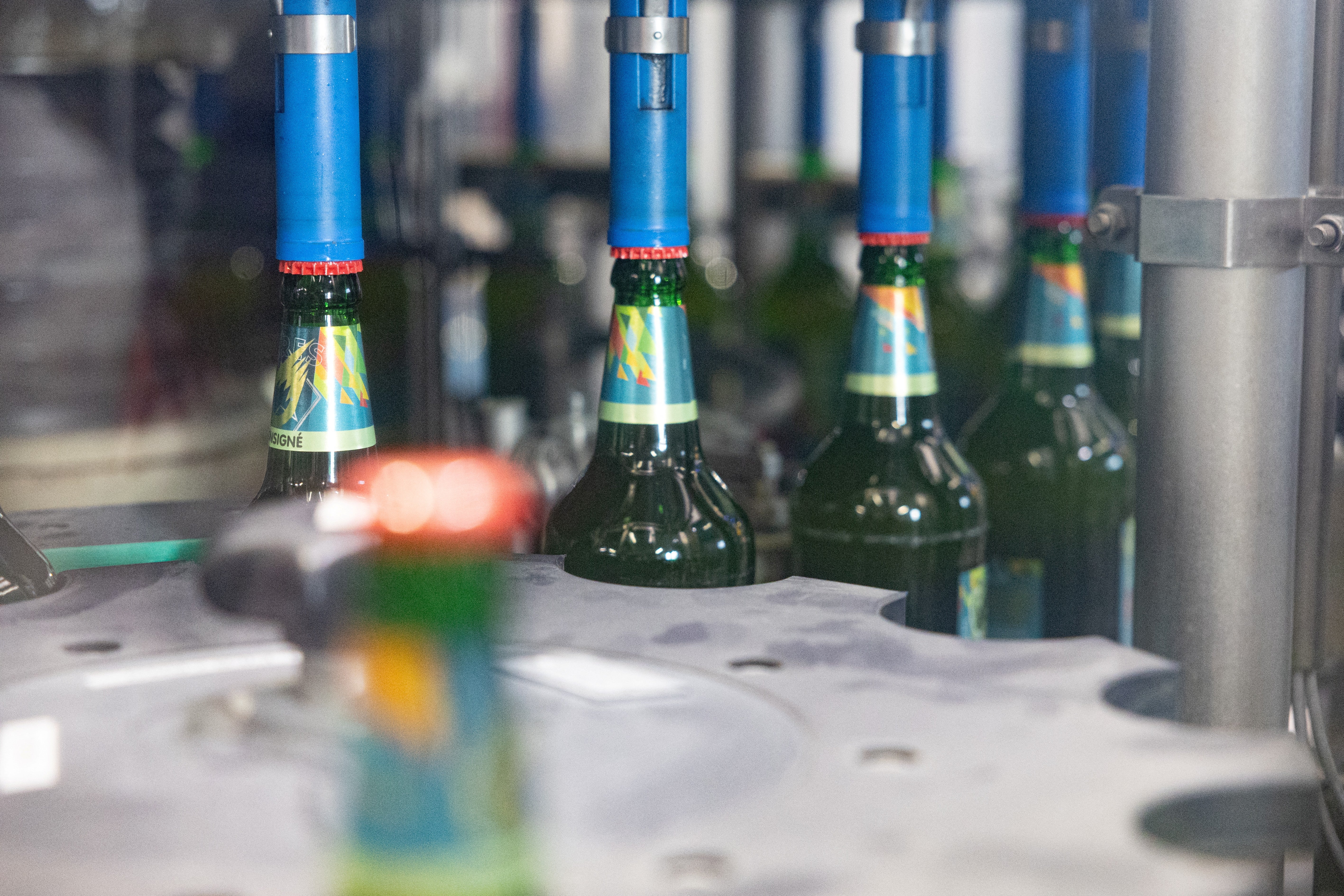 Machine placing traffic jams on beer bottles on a mounting chain