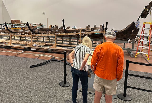 <p>Visitors to the New York State Museum view a Revolutionary War-era gunboat that is being partially reconstructed</p>