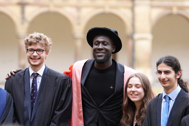 Stormzy has a picture with students after receiving his honorary degree from Cambridge University (PA)