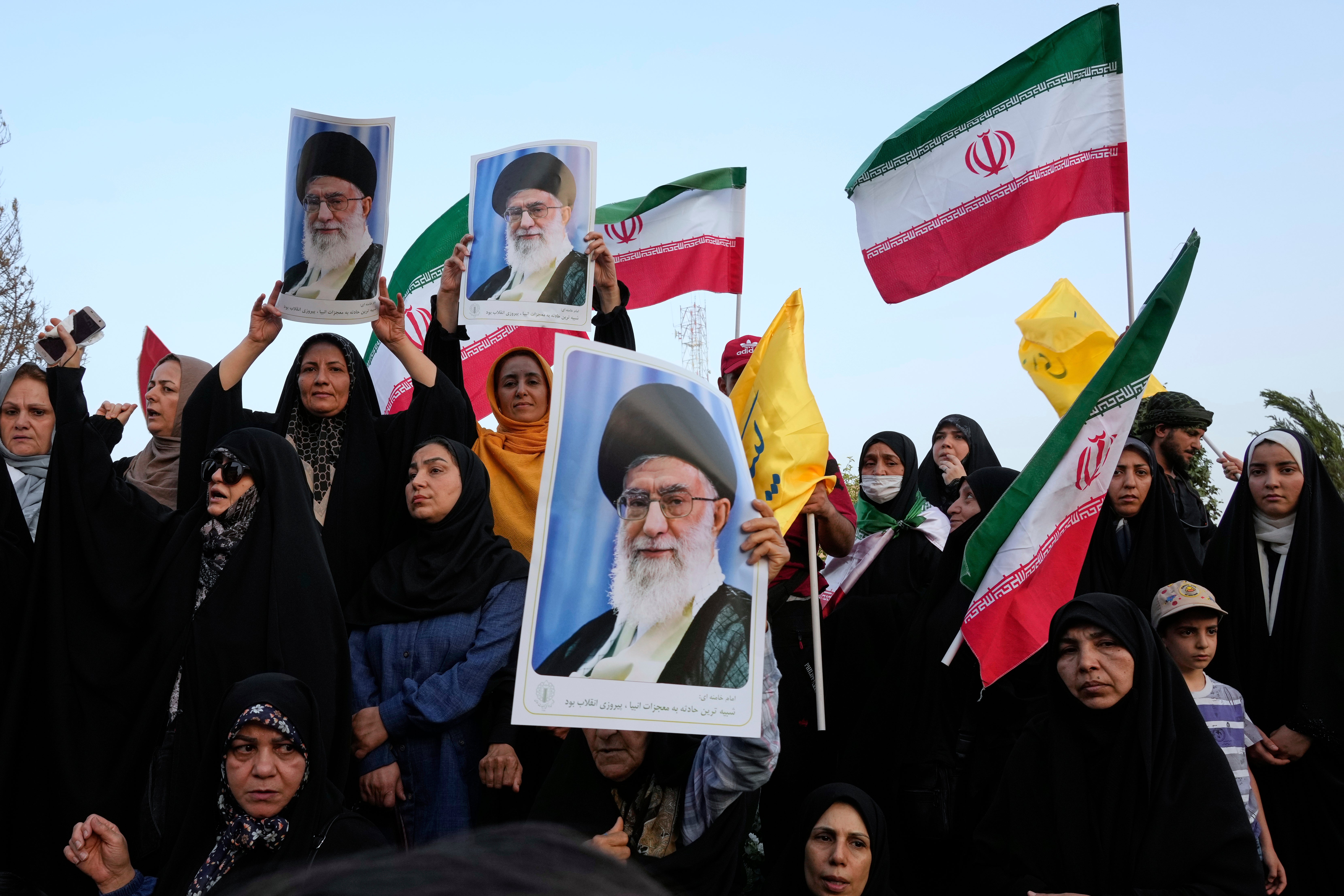 Iranian protesters hold their country's flags and posters of Supreme Leader Ayatollah Ali Khamenei in an anti-US and anti-Israel rally