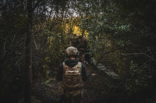 Les soldats se dirigeant vers la forêt jusqu'à l'obusier de 122 mm 2A18, alors que la 117e brigade de défense du territoire et les troupes ukrainiennes exploitent de l'artillerie dans la région de Smie.