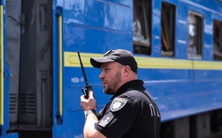 Les policiers s'expriment à la radio près du train de passagers endommagés à la suite d'un énorme bombardement russe dans la ville de Dnipro