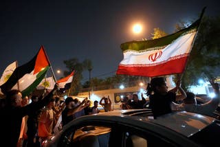 Protesters in Iraq gather in front of the Iranian Embassy in celebration of the ceasefire between Iran and Israel