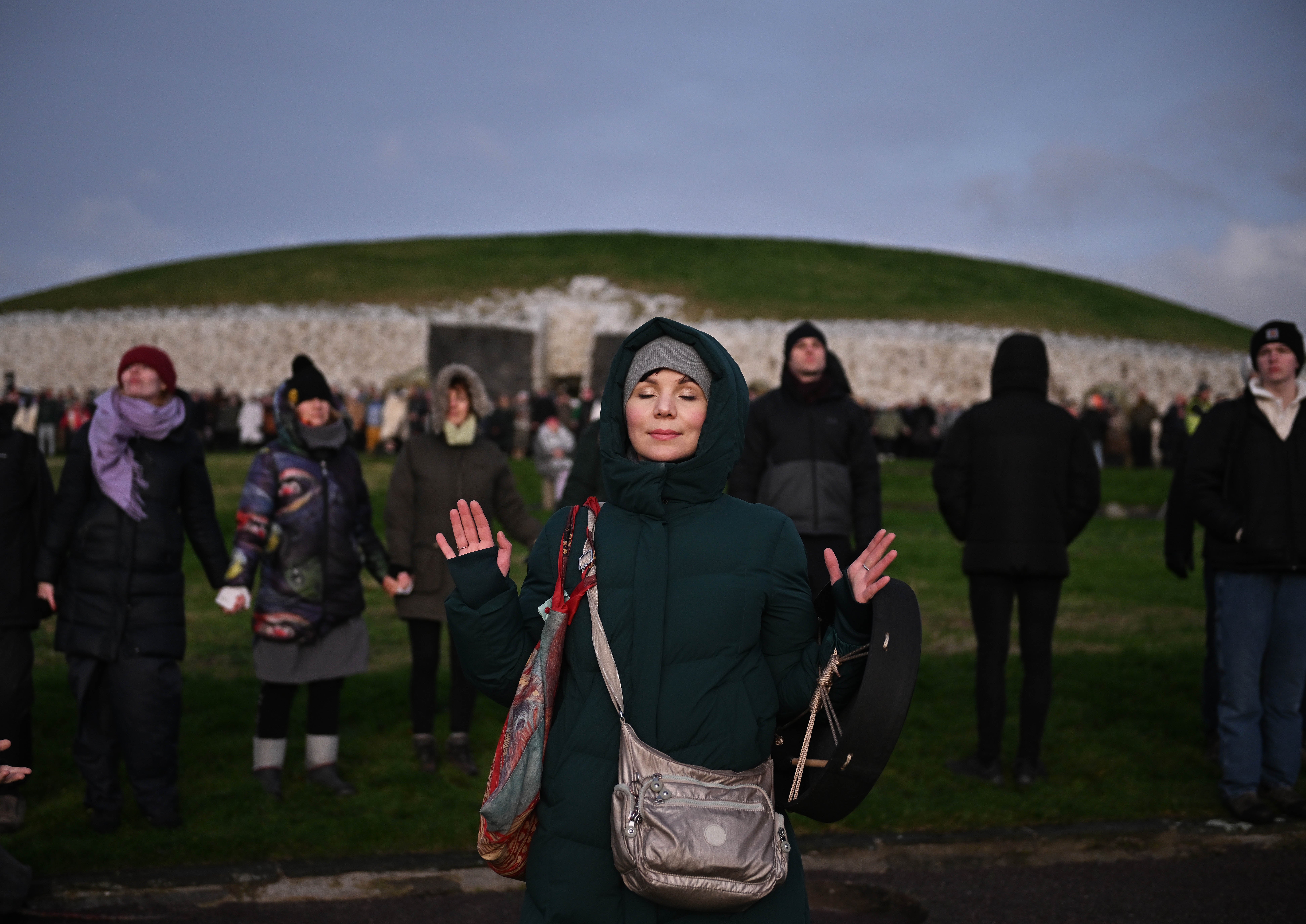 People take part in a sun rise ceremony during the Winter Solstice at Newgrange