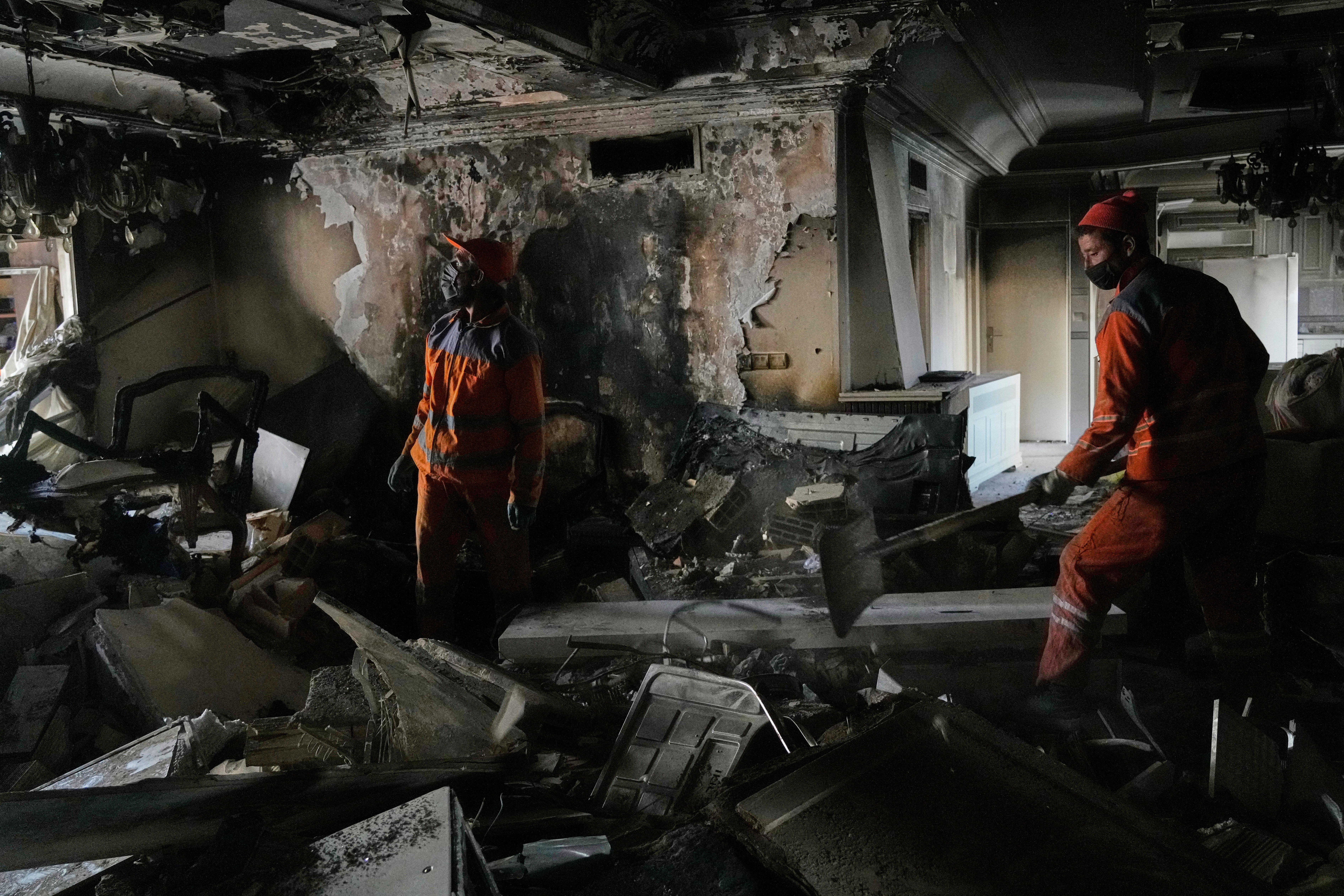 Workers clear rubble of a damaged building, in Tehran after an Israeli strike