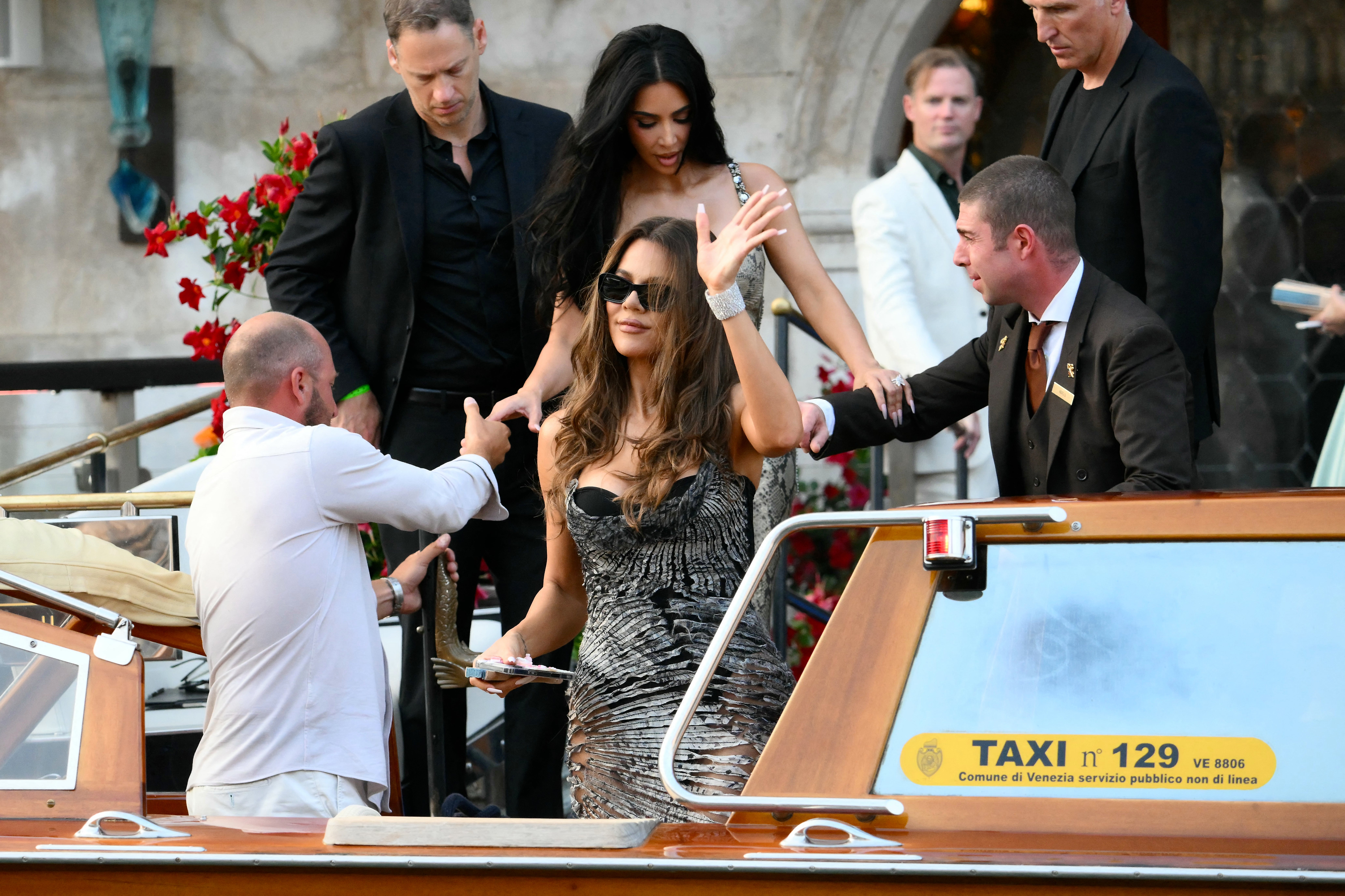 Khloe Kardashian headed to Bezos’s welcome party in a black corset, worn underneath a silver printed dress. The design of the gown was a bit messy, as it looked like it was slightly cut open in various spots