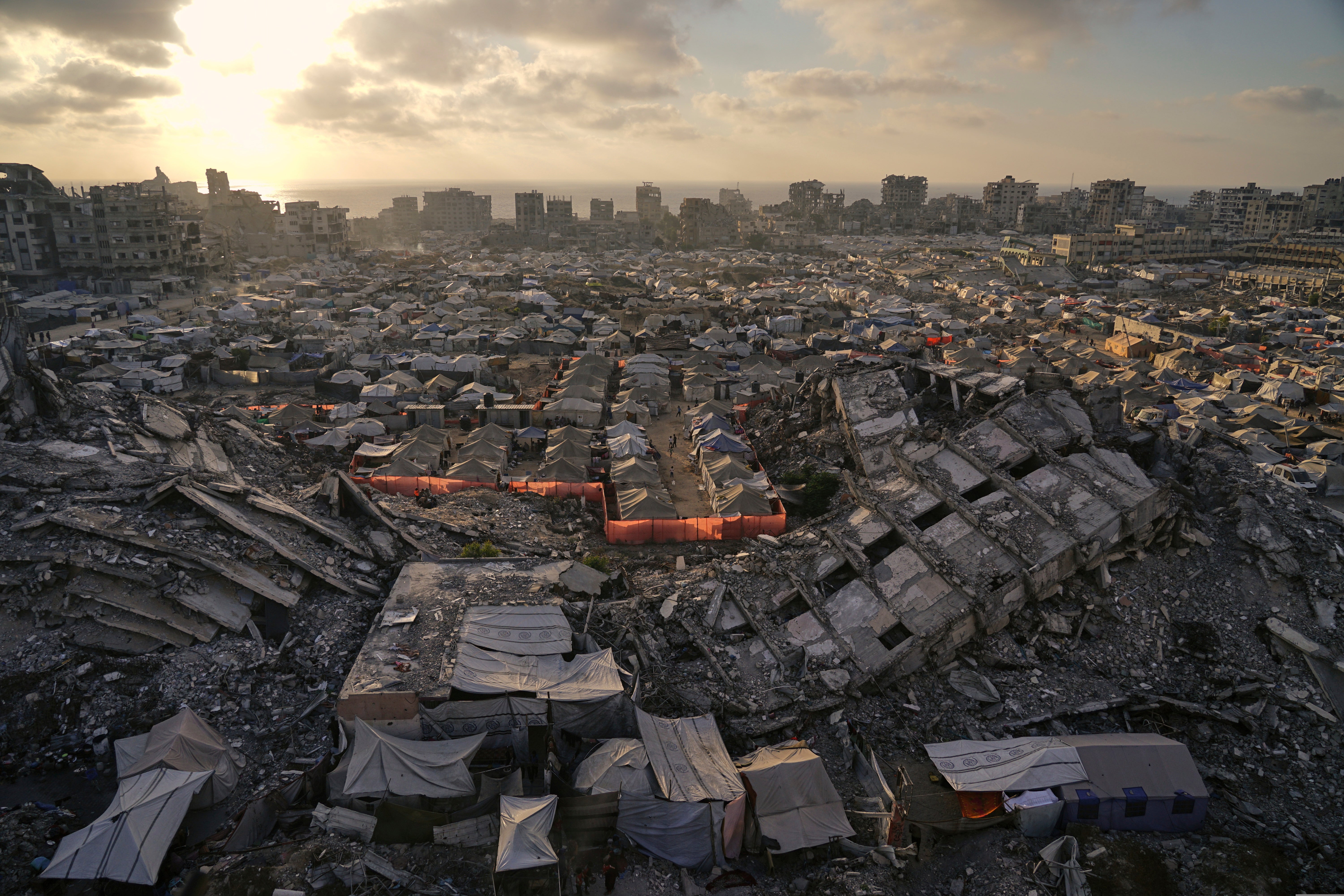 A tent camp for displaced Palestinians stretches among the ruins of buildings destroyed by Israeli bombardments in west of Gaza City, Saturday, June 21, 2025
