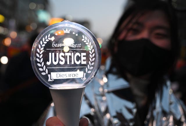 <p>File. Representative. A protester holds a light stick reading 'Justice' during a rally in Seoul on 4 April 2025</p>