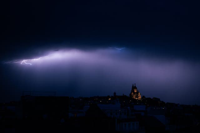 <p>A lighting bolt lights up the sky over Sacre Coeur Basilica in Montmartre during a thunderstorm, northern Paris, on June 25, 2025</p>