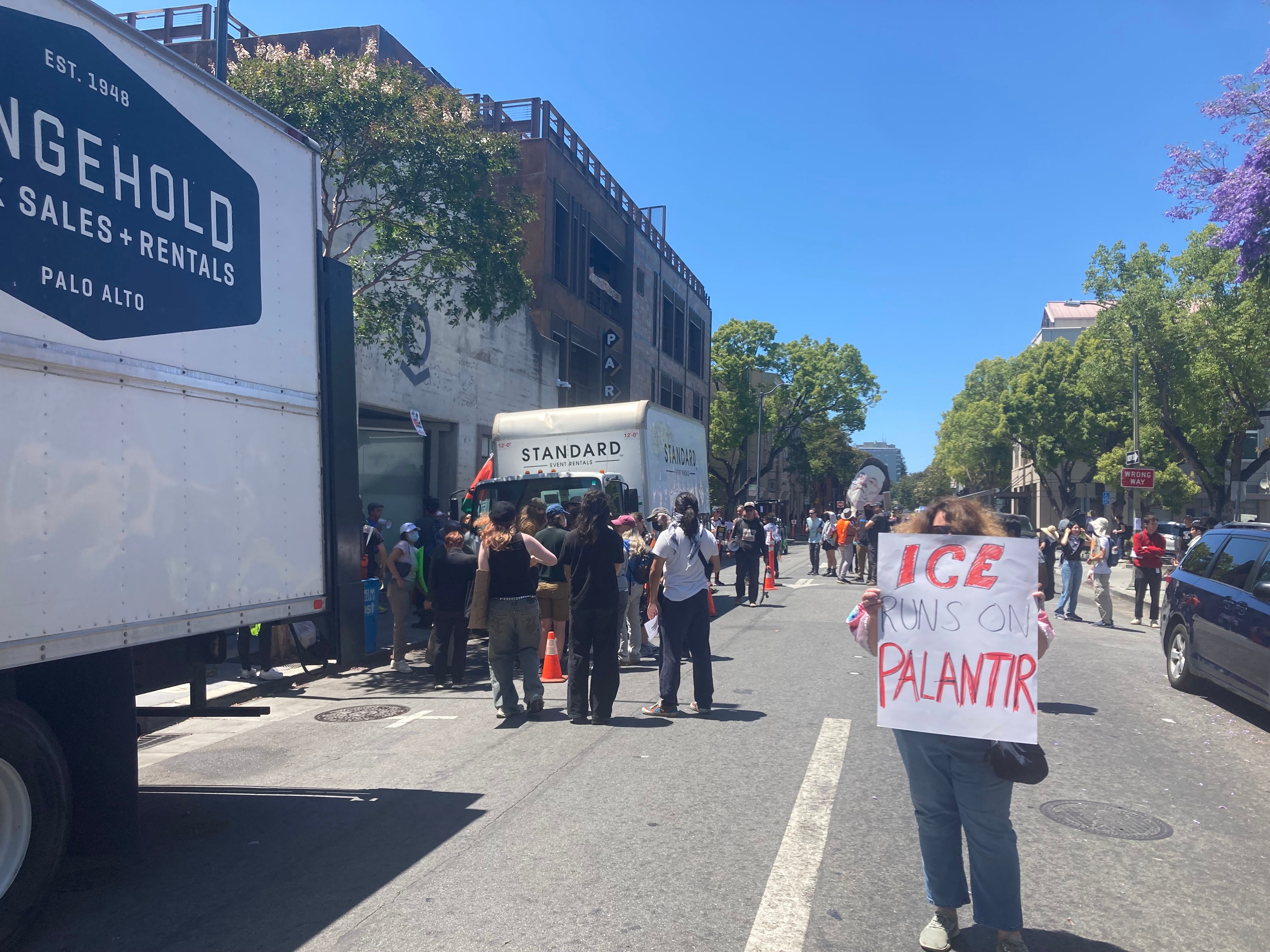 Protesters gather outside the supposed location of Palantir's developer conference, along with confused delivery drivers