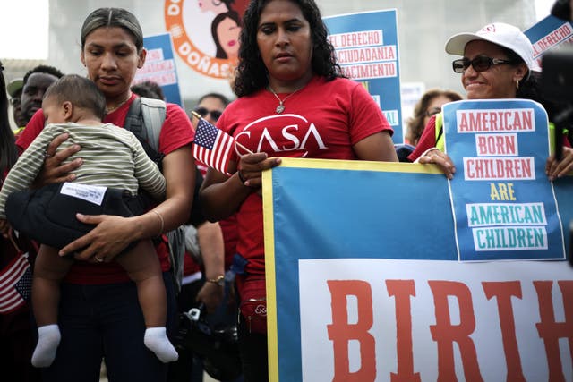 <p>Olga Urbina, left, and her 9-month-old son Ares Webster join demonstrations outside the Supreme Court on May 14 as justices grill the Trump administration over challenges to birthright citizenship</p>