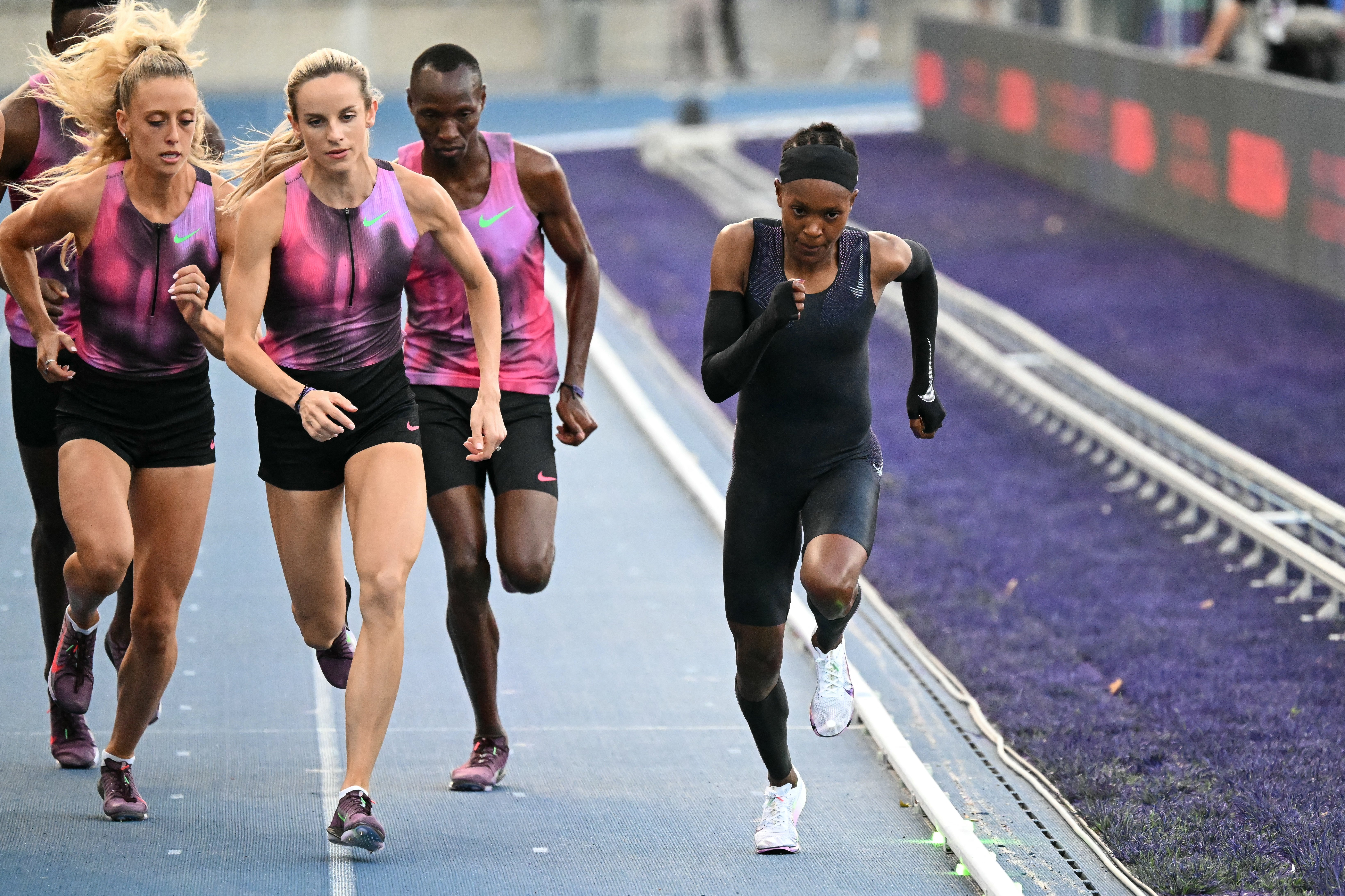 Georgia Hunter Bell runs alongside Kenya's Faith Kipyegon at the Stade Charlety, Paris