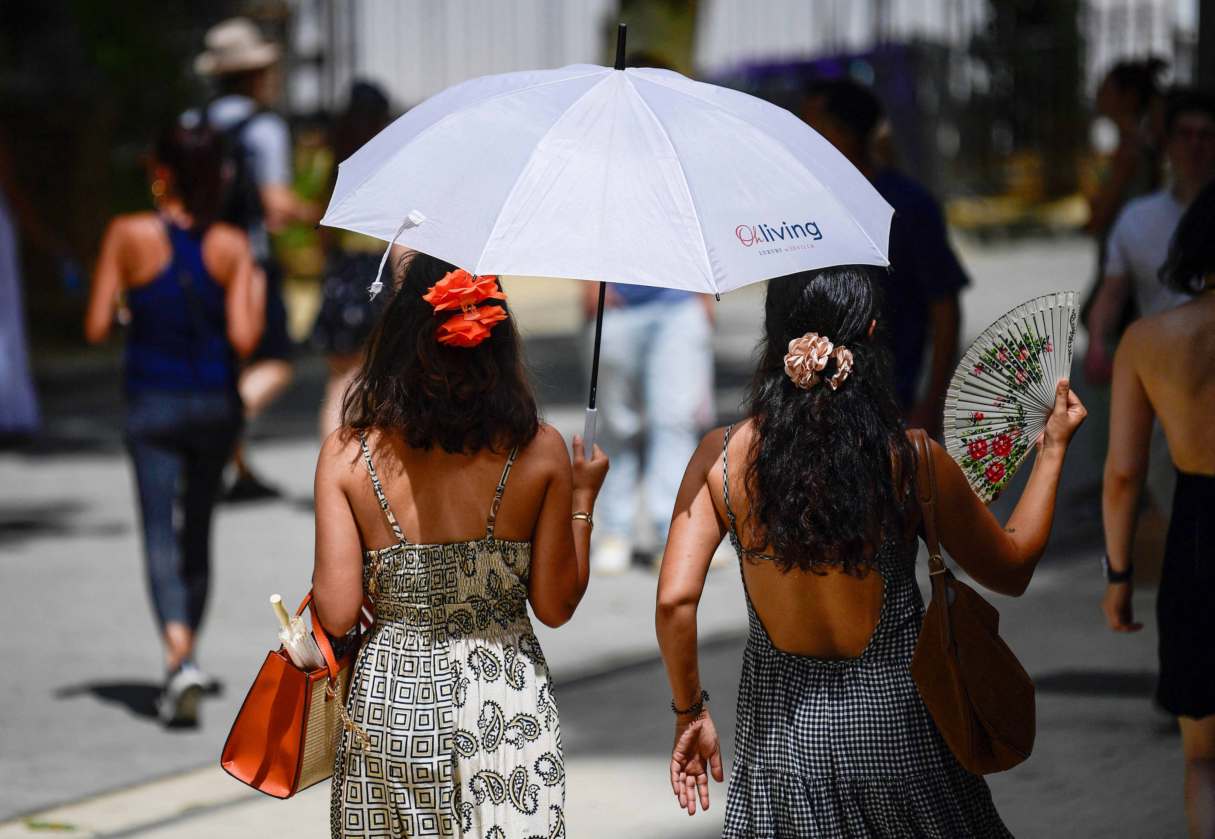 Women use umbrellas to stay cool during the heatwave in Spain’s Seville