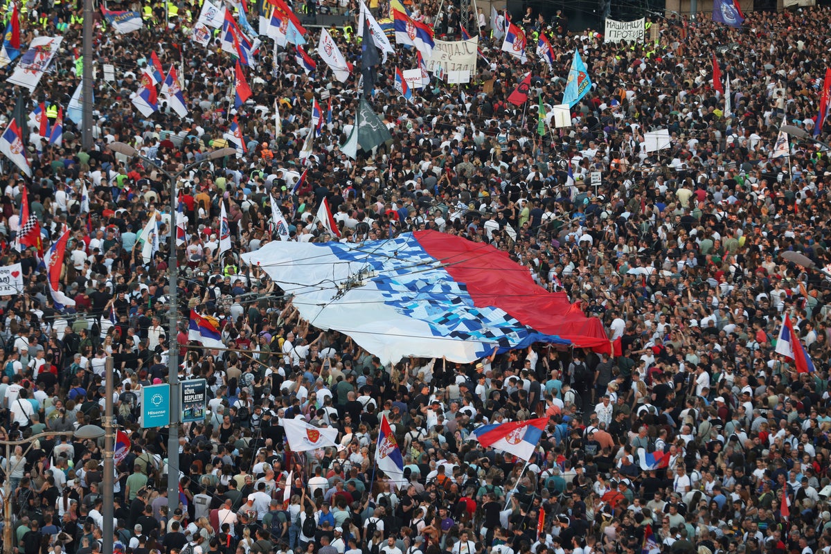 Tens of thousands rally in Serbia's capital to back up their demand for an early vote