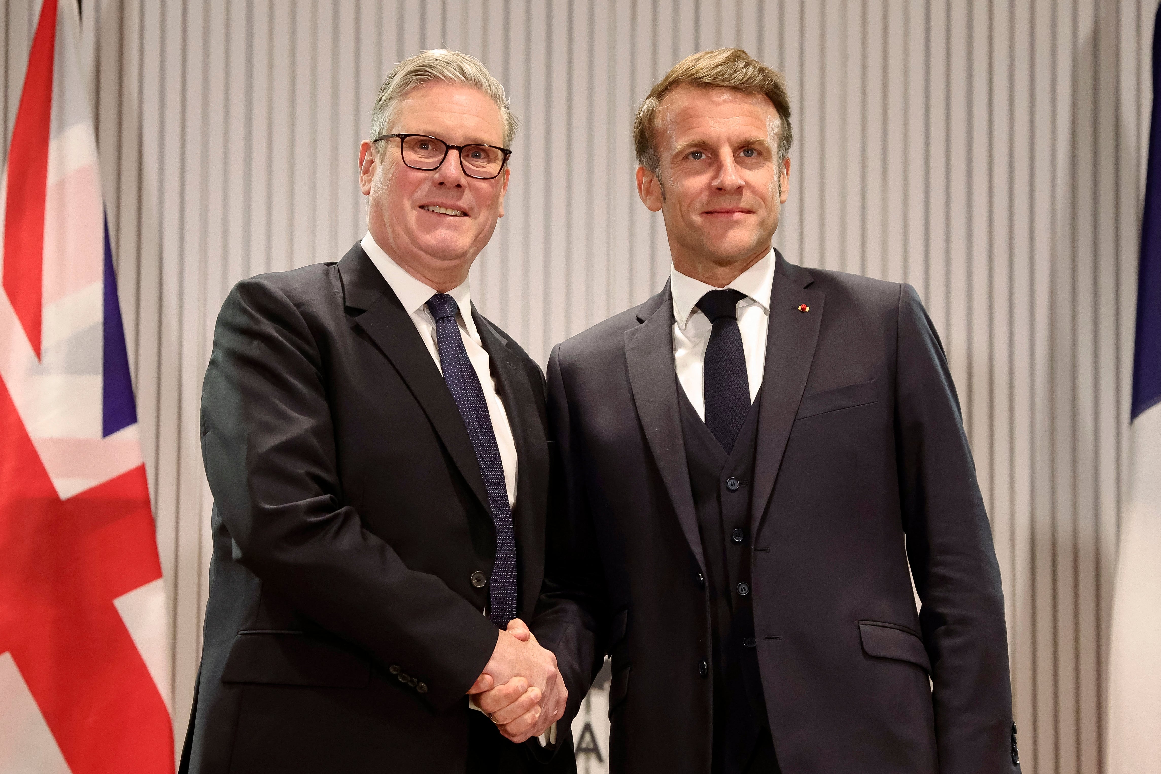 French President Emmanuel Macron (R) shakes hands with British Prime Minister Keir Starmer