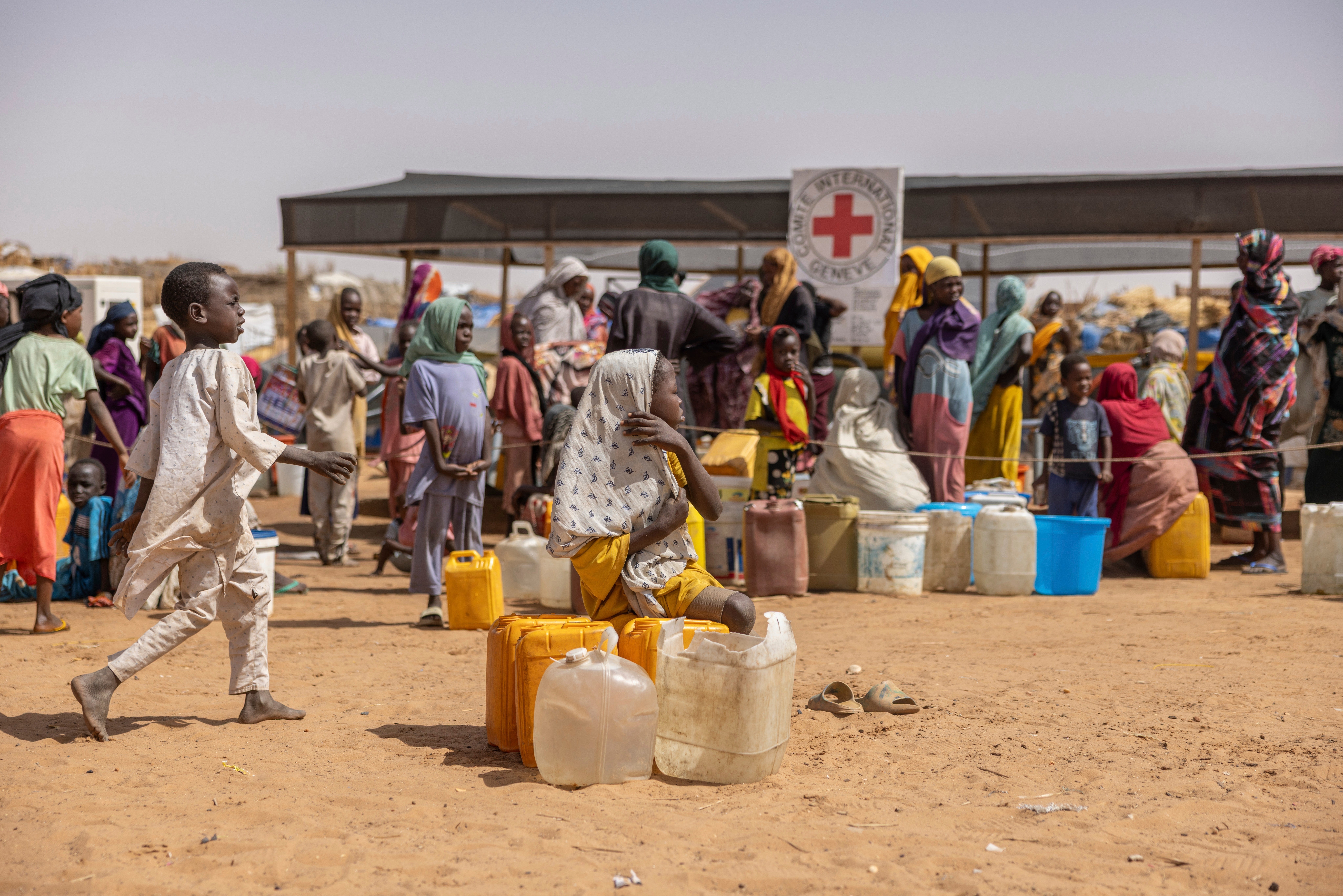 Sudan refugees queue at a Red Cross water point in the Adre, Chad