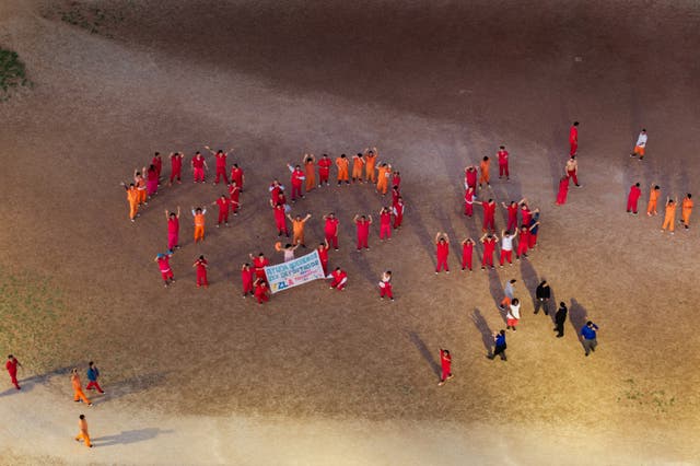<p>Immigration detainees in Anson, Texas, form a human ‘S.O.S.’ sign while displaying a banner saying "Help we want to be deported we are not terrorists, S.O.S.,"  in the courtyard at the Bluebonnet Detention Center on May 12</p>