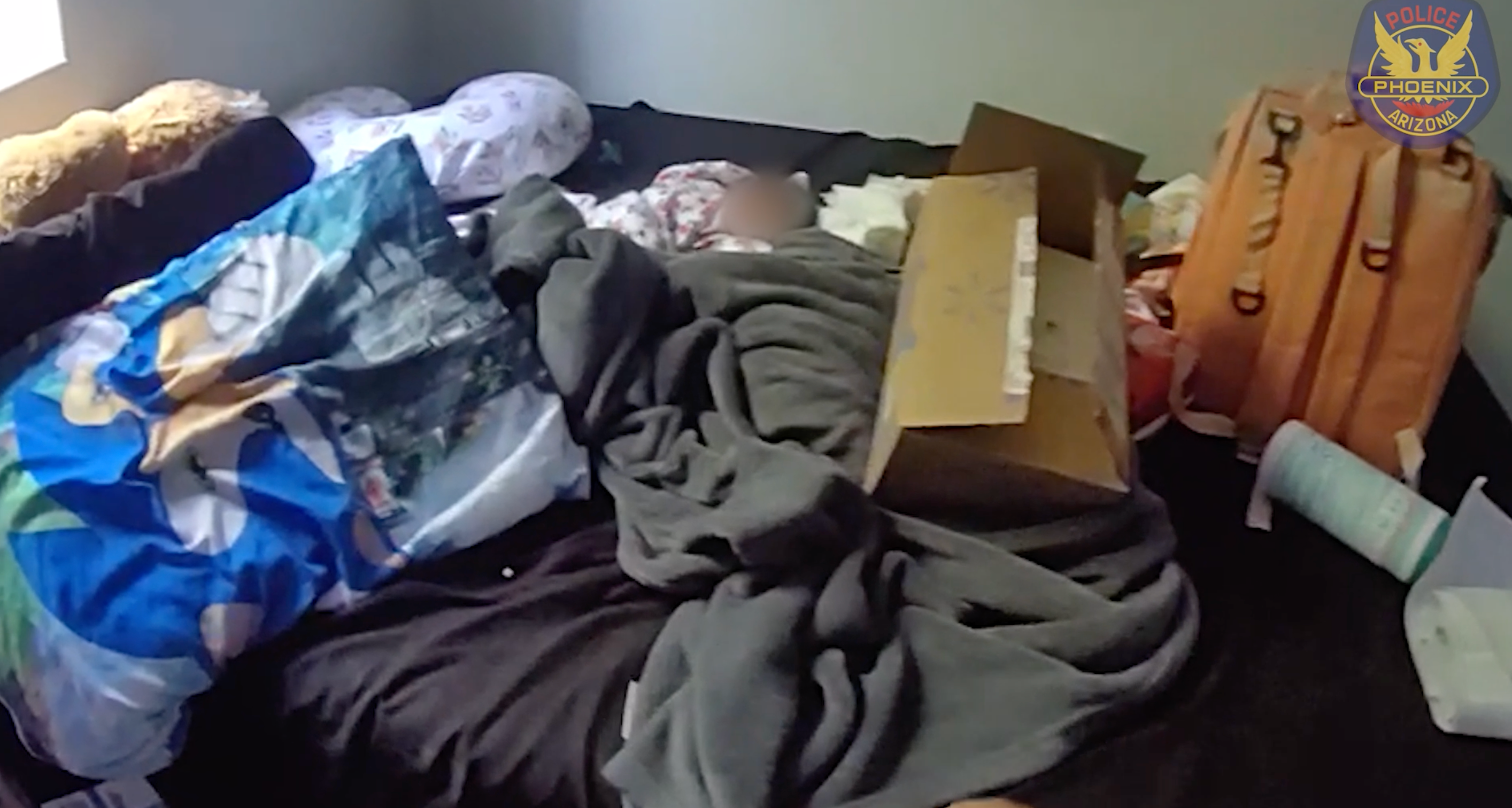 The infant was found lying on a bed after its mother died. Neighbors were praised for raising the alarm