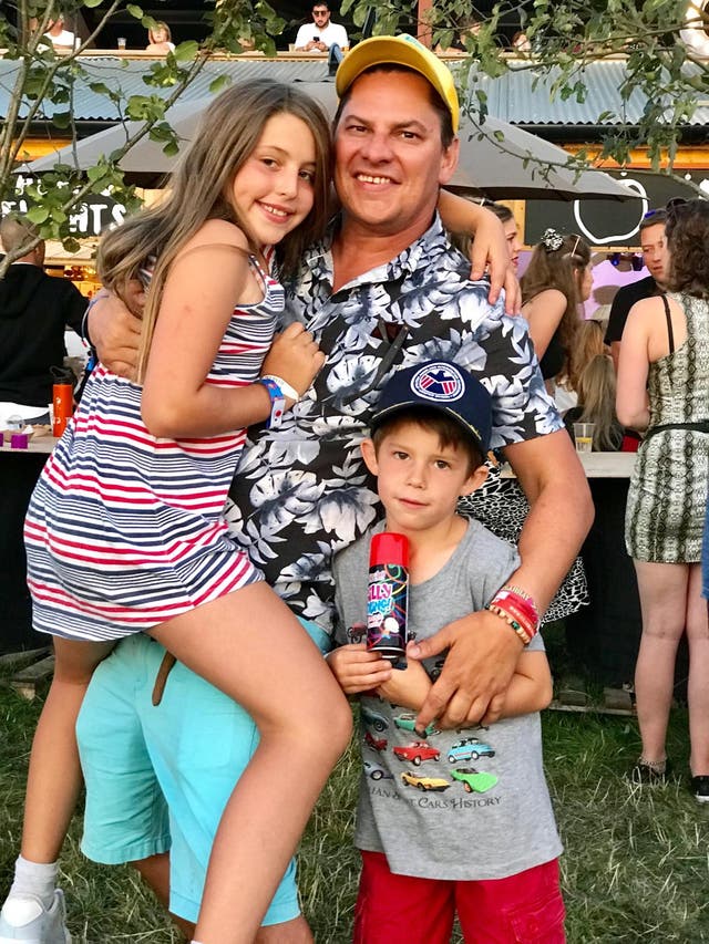 <p>Mark Ackred, 47, is pictured with his daughter and son, who were 11 and seven at the time, earlier in the day before he was spiked</p>