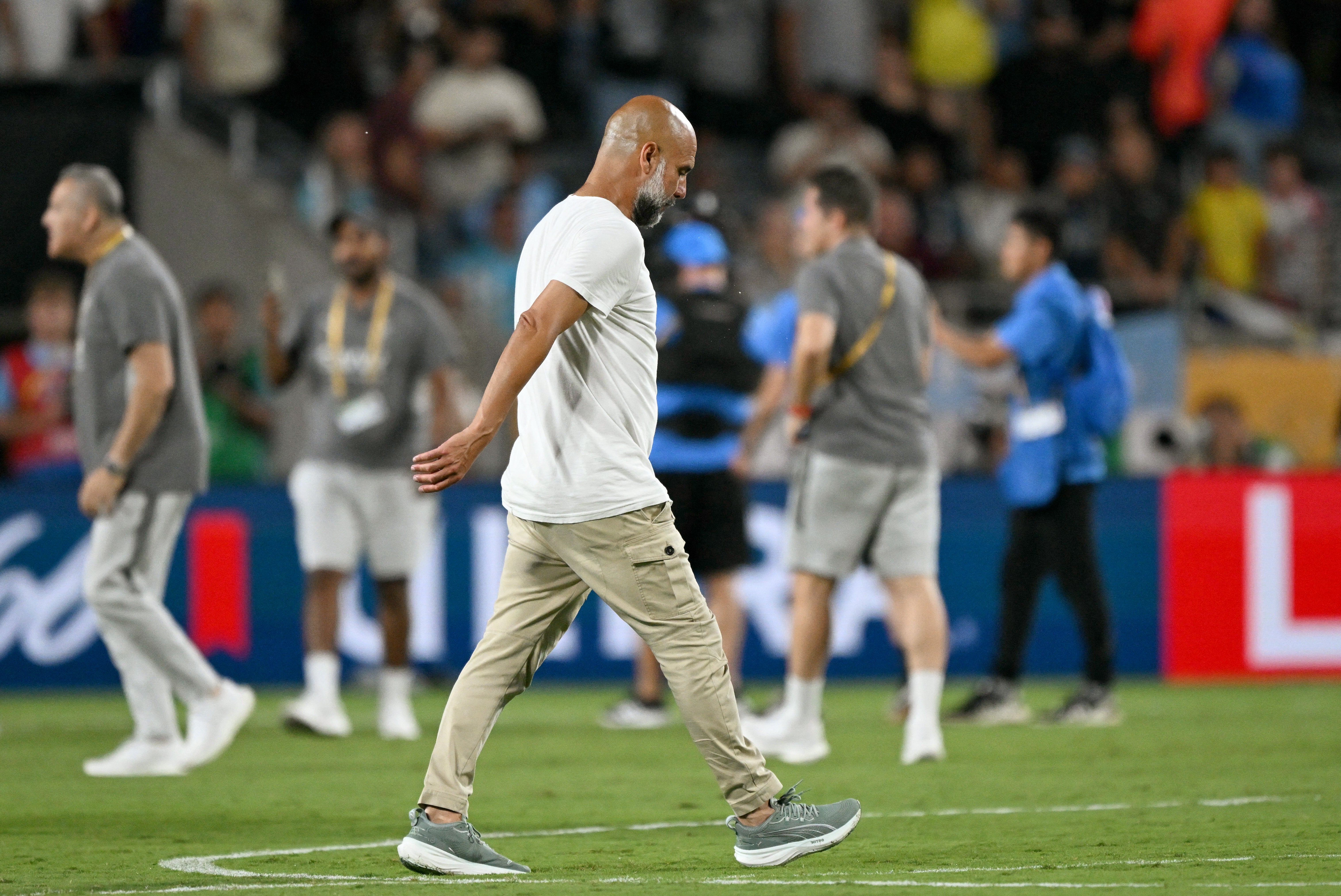 <p> Pep Guardiola walks on the pitch after losing the FIFA Club World Cup 2025 round of 16 football match between England's Manchester City and Saudi's Al-Hilal </p>