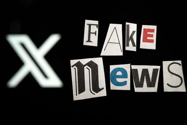 <p>An illustration photo shows letters cut out of newspapers arranged to read "fake news" set up in front of a screen displaying the logo of the social media platform X</p>