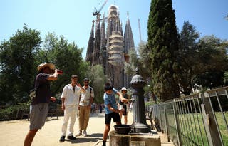 People fill up their bottles from a fountain next to Sagrada Familia Basilica during a heatwave in Barcelona