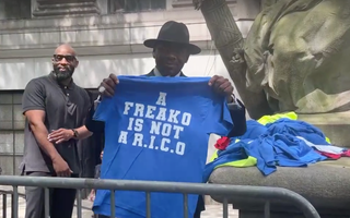 A man hands out free T-shirts outside of Diddy's trial in New York