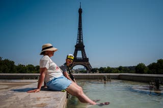 Tourists cool off in the Trocadero Fountain, in front of the Eiffel Tower in Paris
