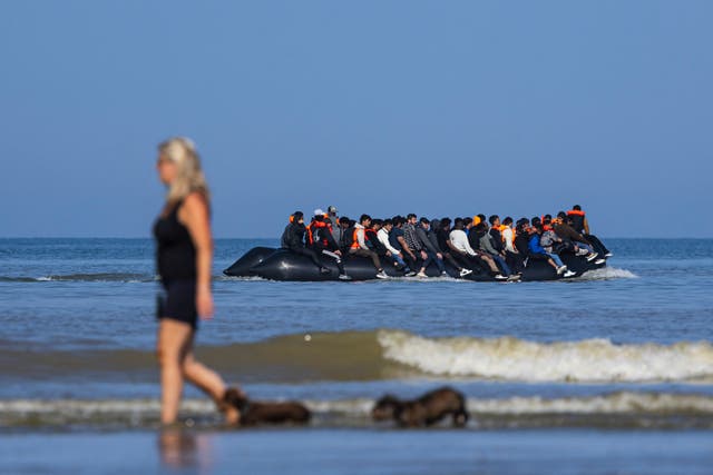 <p>Migrants board a boat off the beach of Hardelot, northern France, on Monday</p>