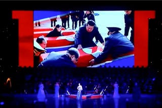 This frame grab from Korean Central Television (KCTV) taken on 29 June and released via AFPTV on 1 July shows a screen displaying North Korea's leader Kim Jong Un looking at coffins during a performance attended by Kim and Russian Minister of Culture Olga Lyubimova in Pyongyang