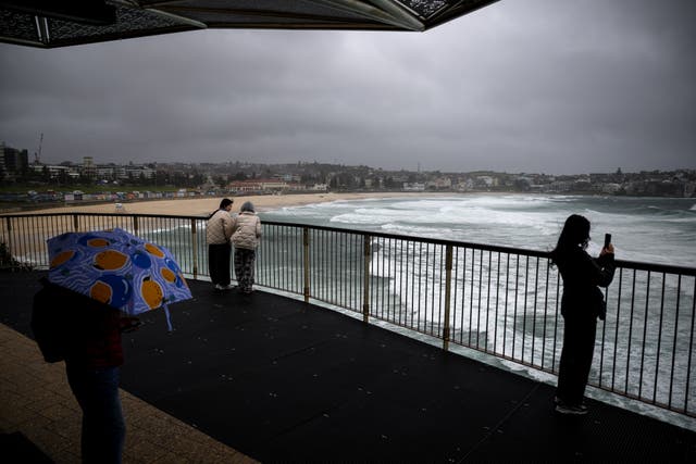 <p>People watch large swells at Bondi Beach in Sydney, Australia</p>