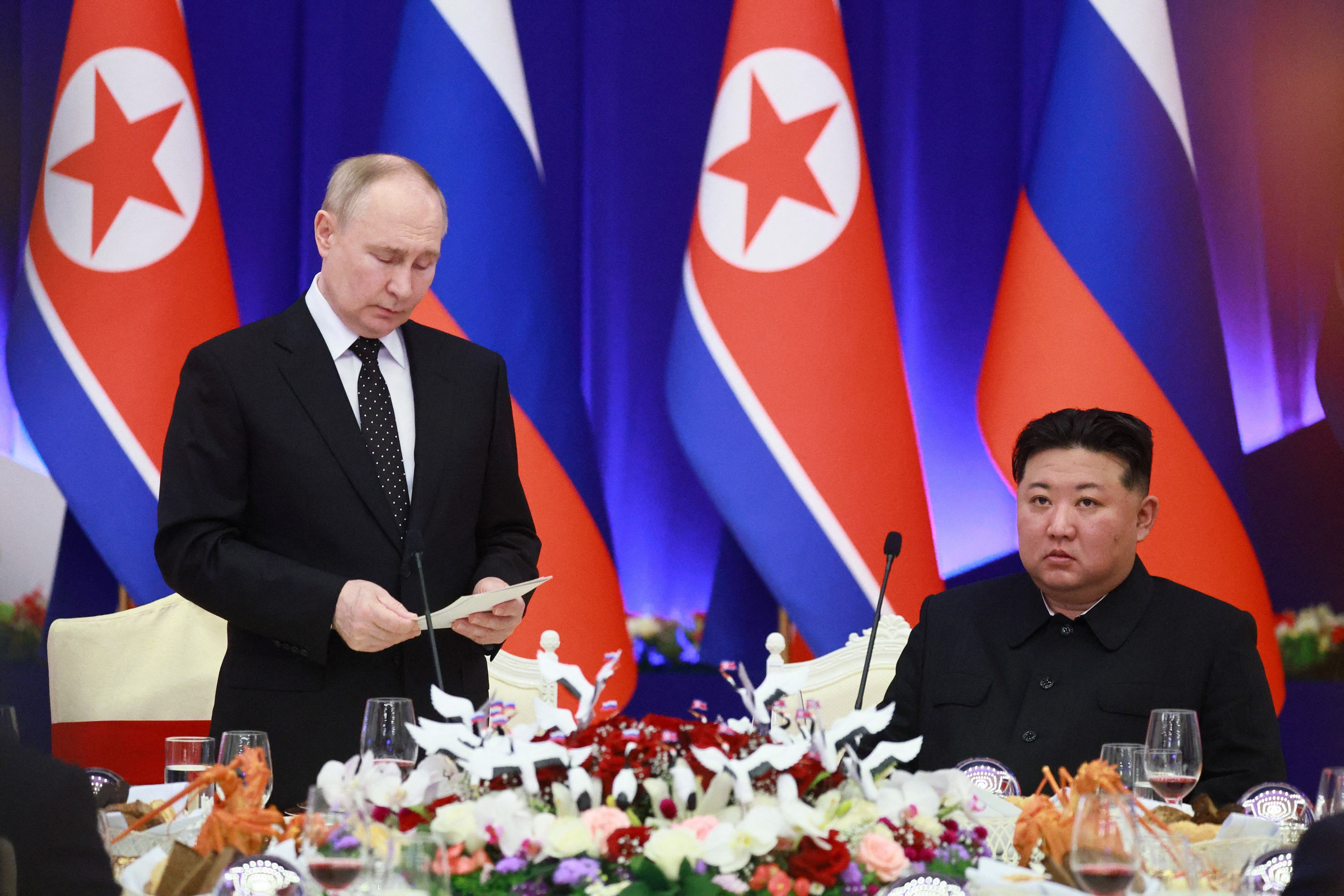 Russian president Vladimir Putin speaks as North Korean leader Kim Jong Un listen during a reception at the Mongnangwan Reception House in Pyongyang on 19 June 2024