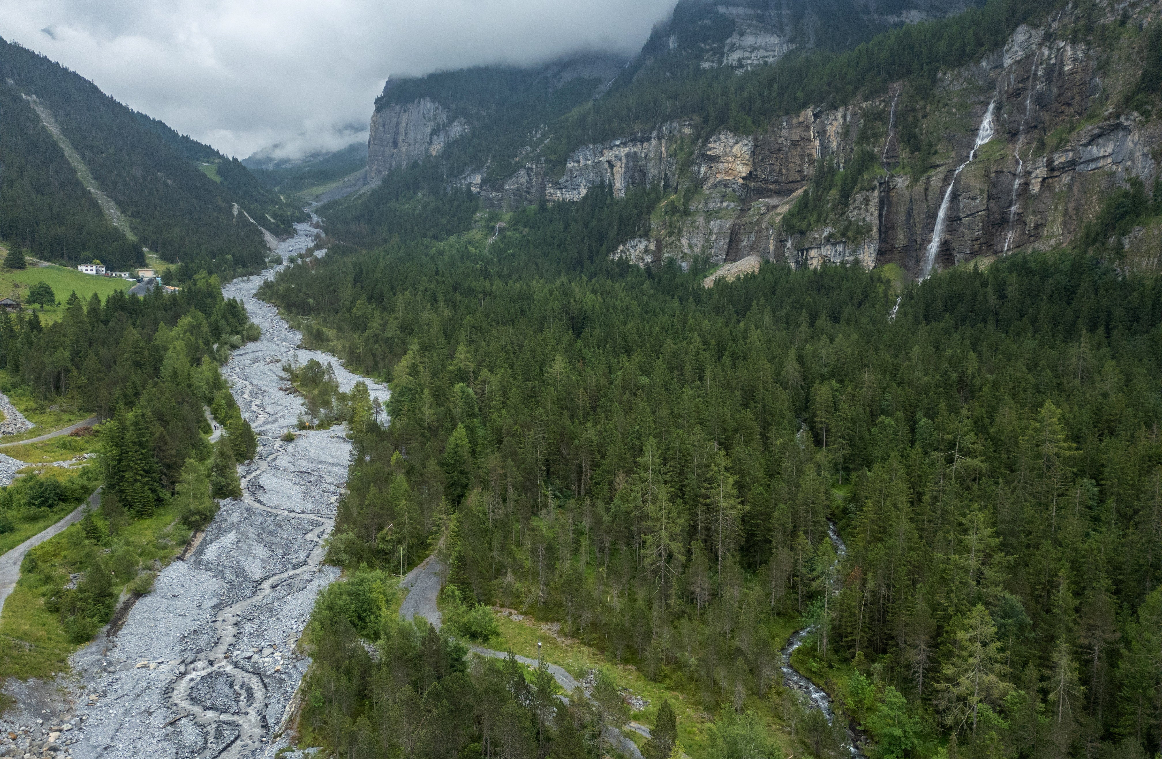 A drone view shows the Oeschiwand (Oeschi Wall) in the Oeschibach River, protecting the village from flash floods and rock falls from Spitzen Stein at Oeschinensee, as climate change and warming permafrost pose increasing challenges in Kandersteg, Switzerland, June 26, 2025. REUTERS/Denis Balibouse