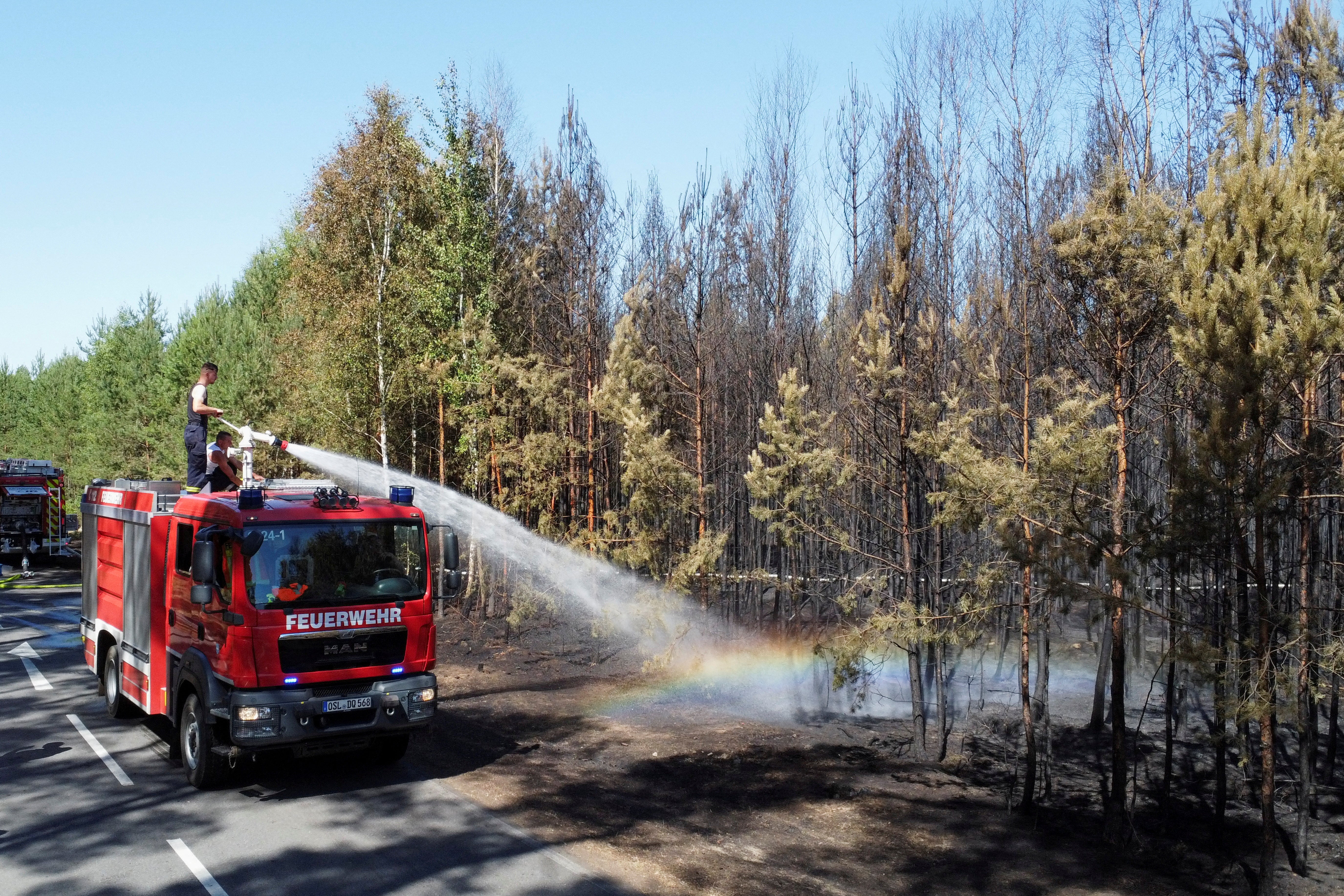 Firefighters work to extinguish a wildfire during a heatwave, nearby the village of Kleinbahren, Germany