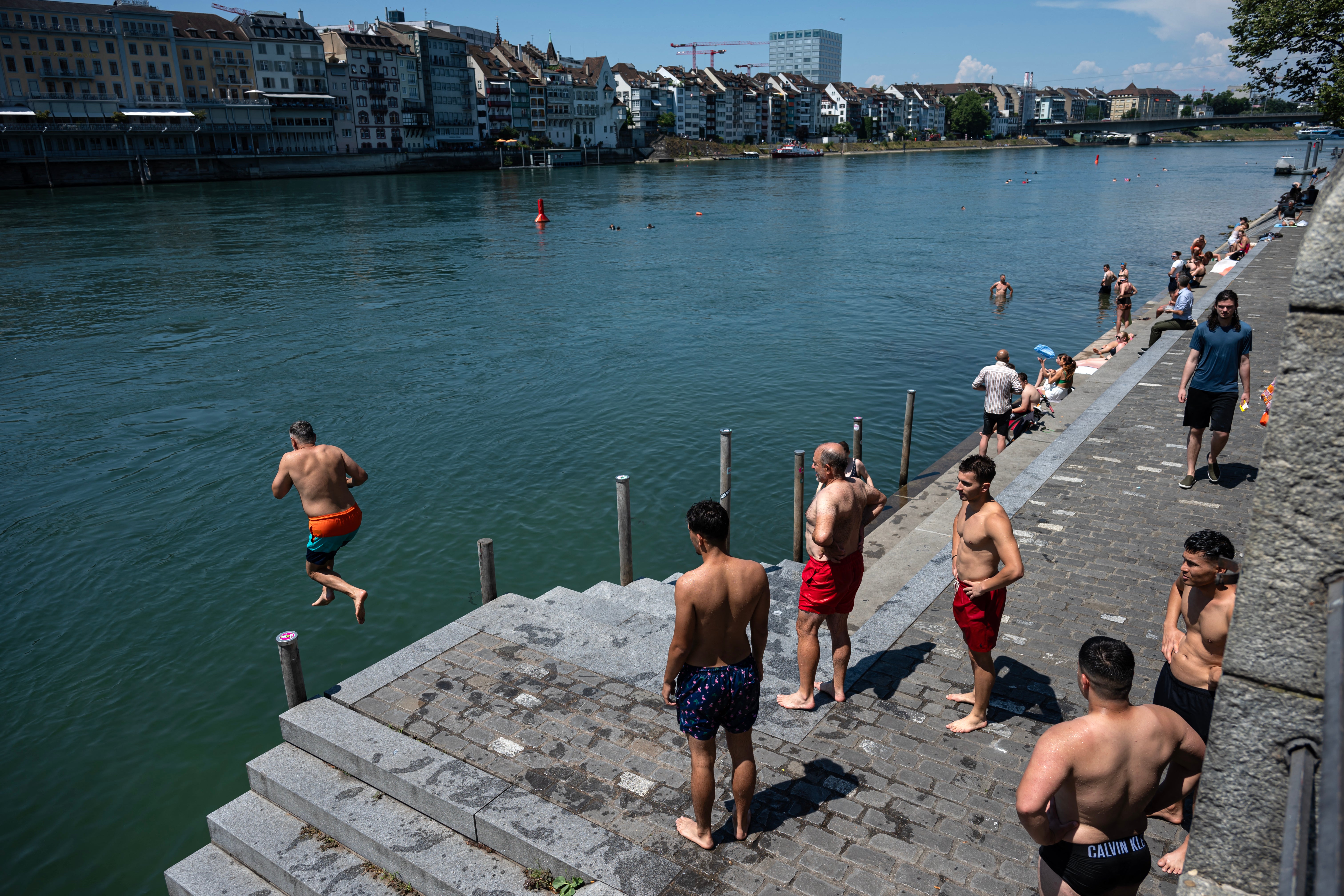 <p>People dive into the Rhine River in Basel, Switzerland, as a heatwave hits Europe</p>