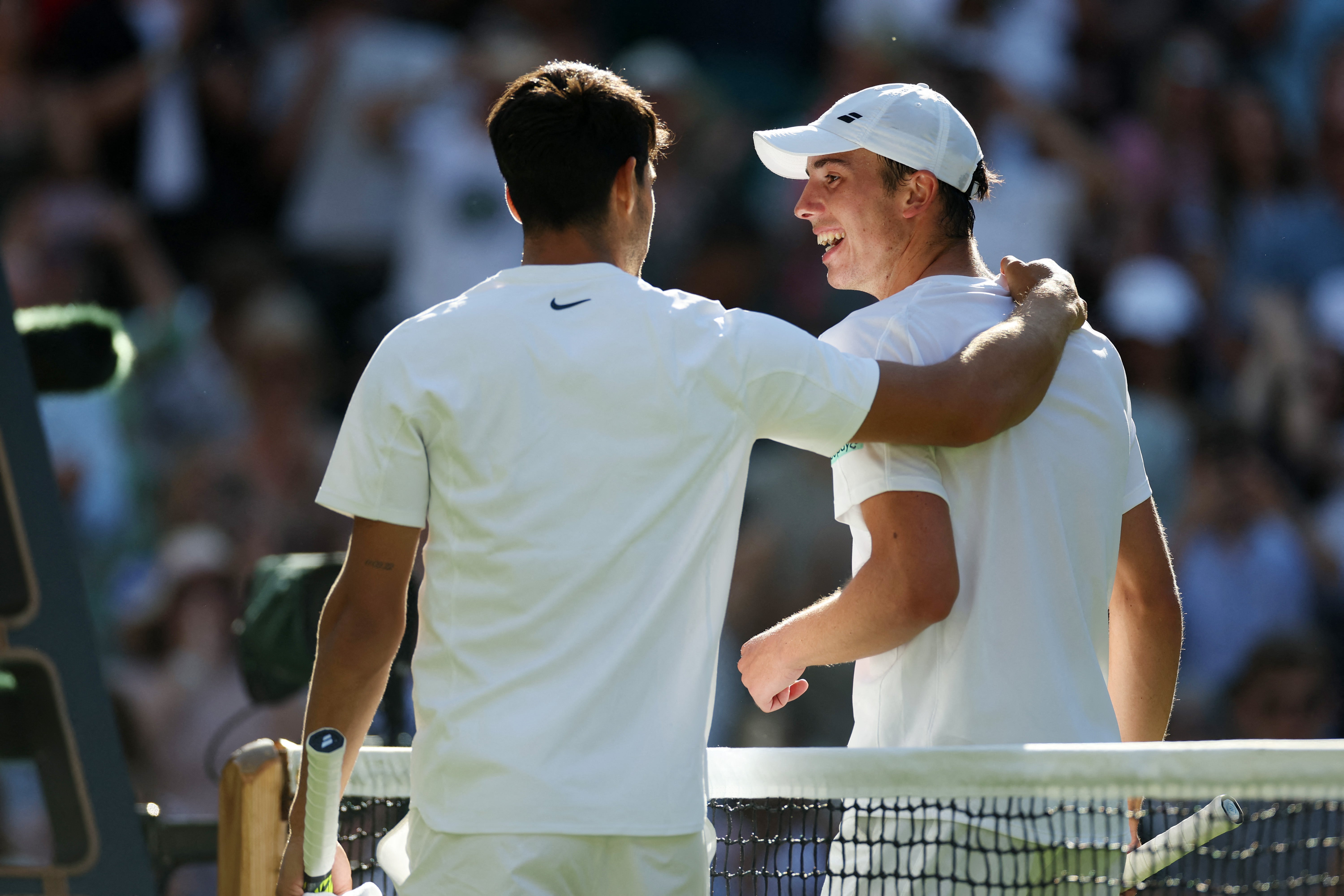 Carlos Alcaraz embraces Ollie Tarvet at the net