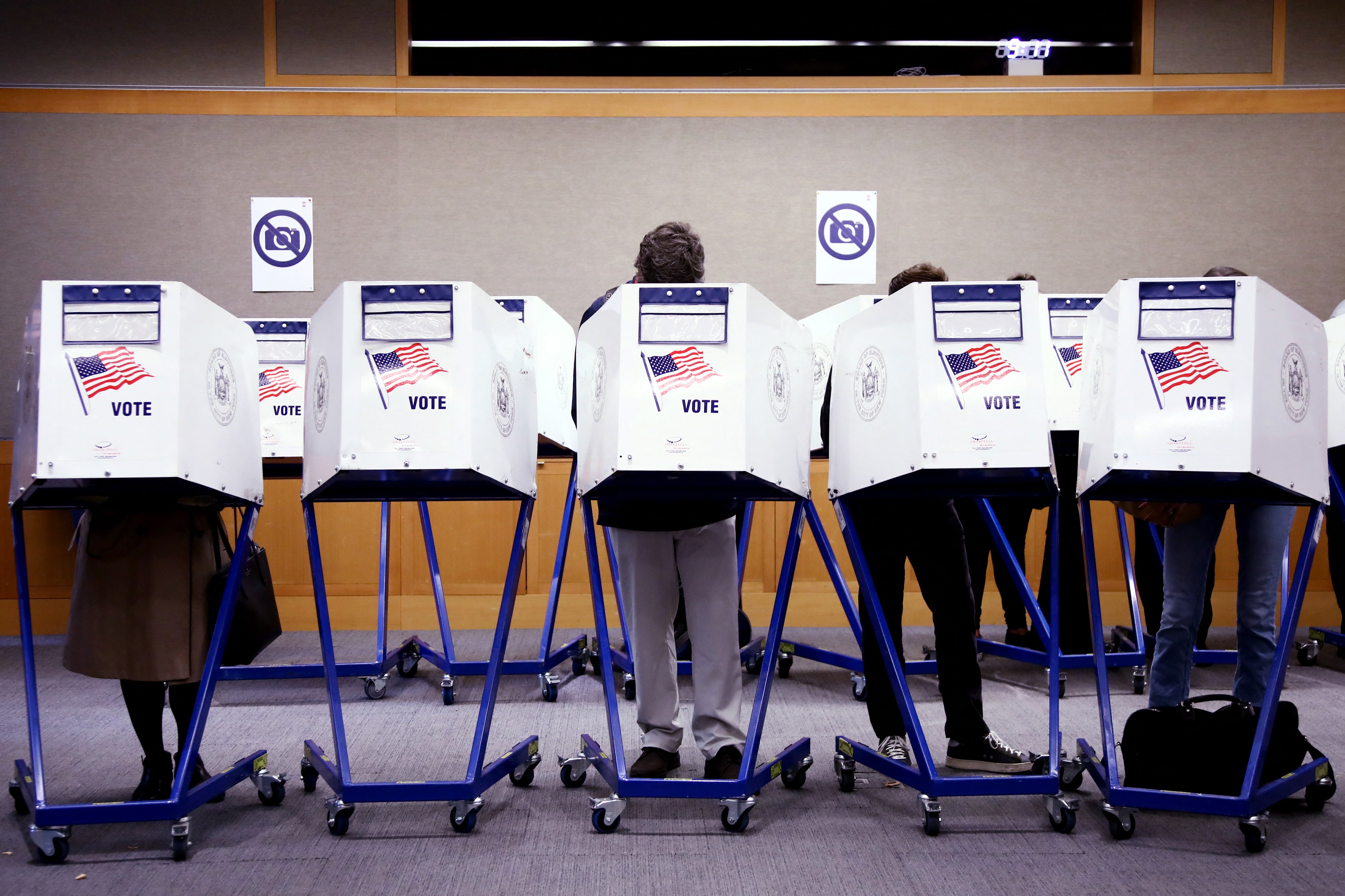 New York City voters pictured filling out their election ballots in November 2024. A new report reveals President Donald Trump's Justice Department is investigating whether it can bring criminal charges against election workers the administration believes aren't safeguarding their computer systems