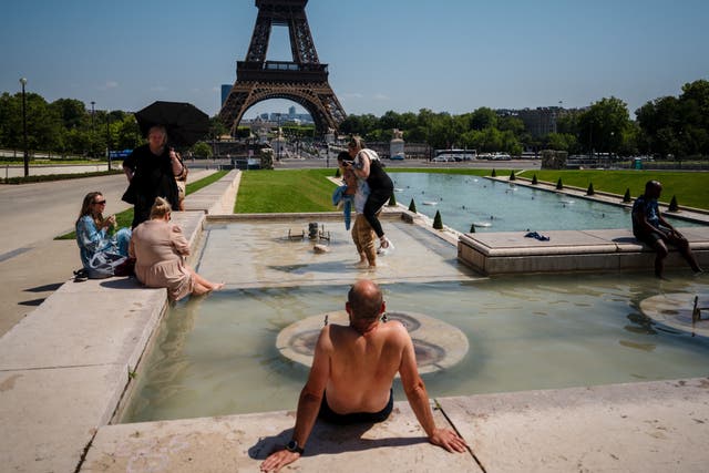 <p>Tourists cool off in the Trocadero Fountain at the foot of the Eiffel Tower in Paris </p>