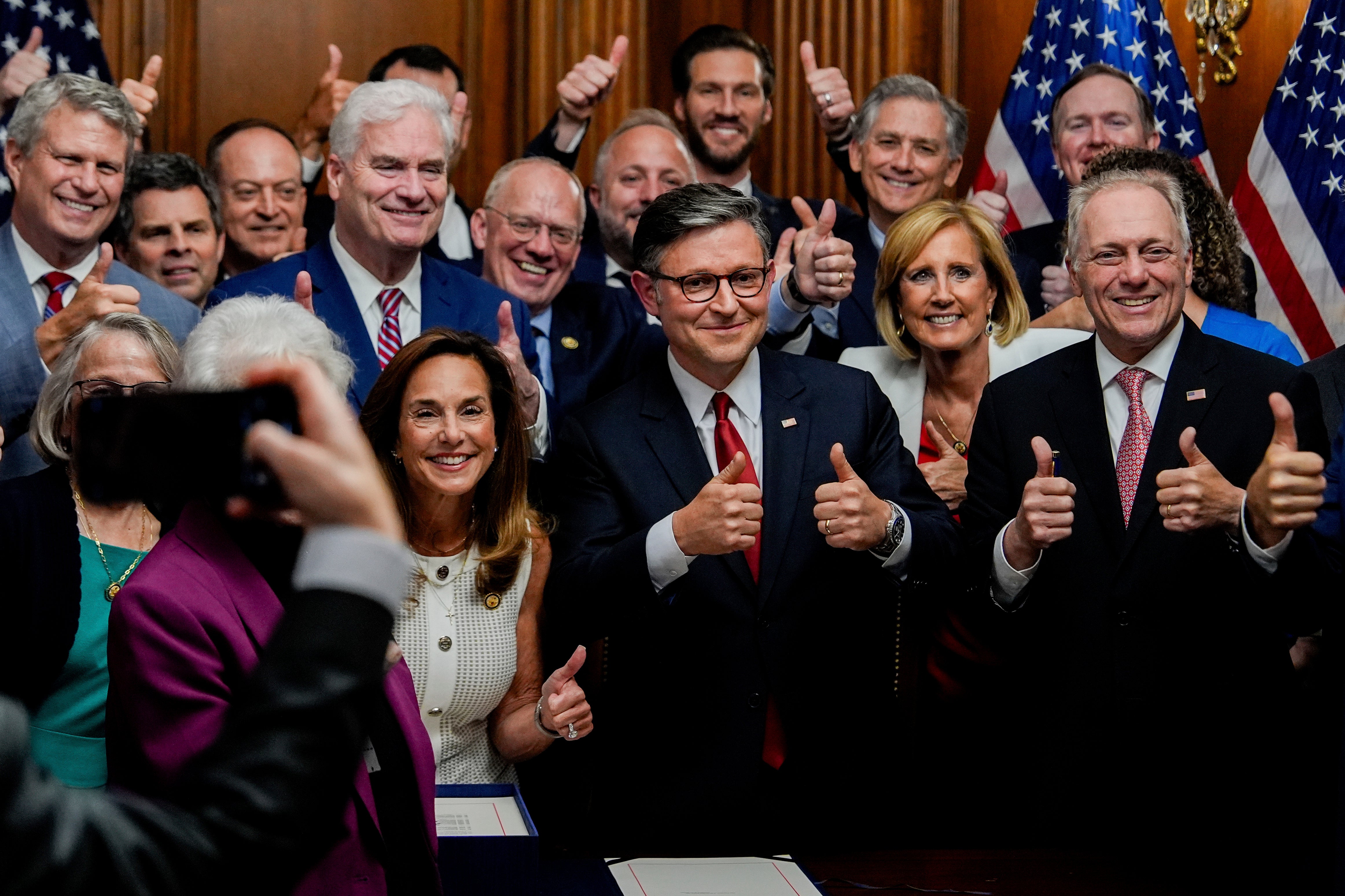 Speaker of the House Mike Johnson (R-LA) surrounded by Republican members of Congress, gives a thumbs up while posing for a photo after signing President Trump's signature bill of tax breaks and spending cuts on July 3, 2025, at the Capitol in Washington