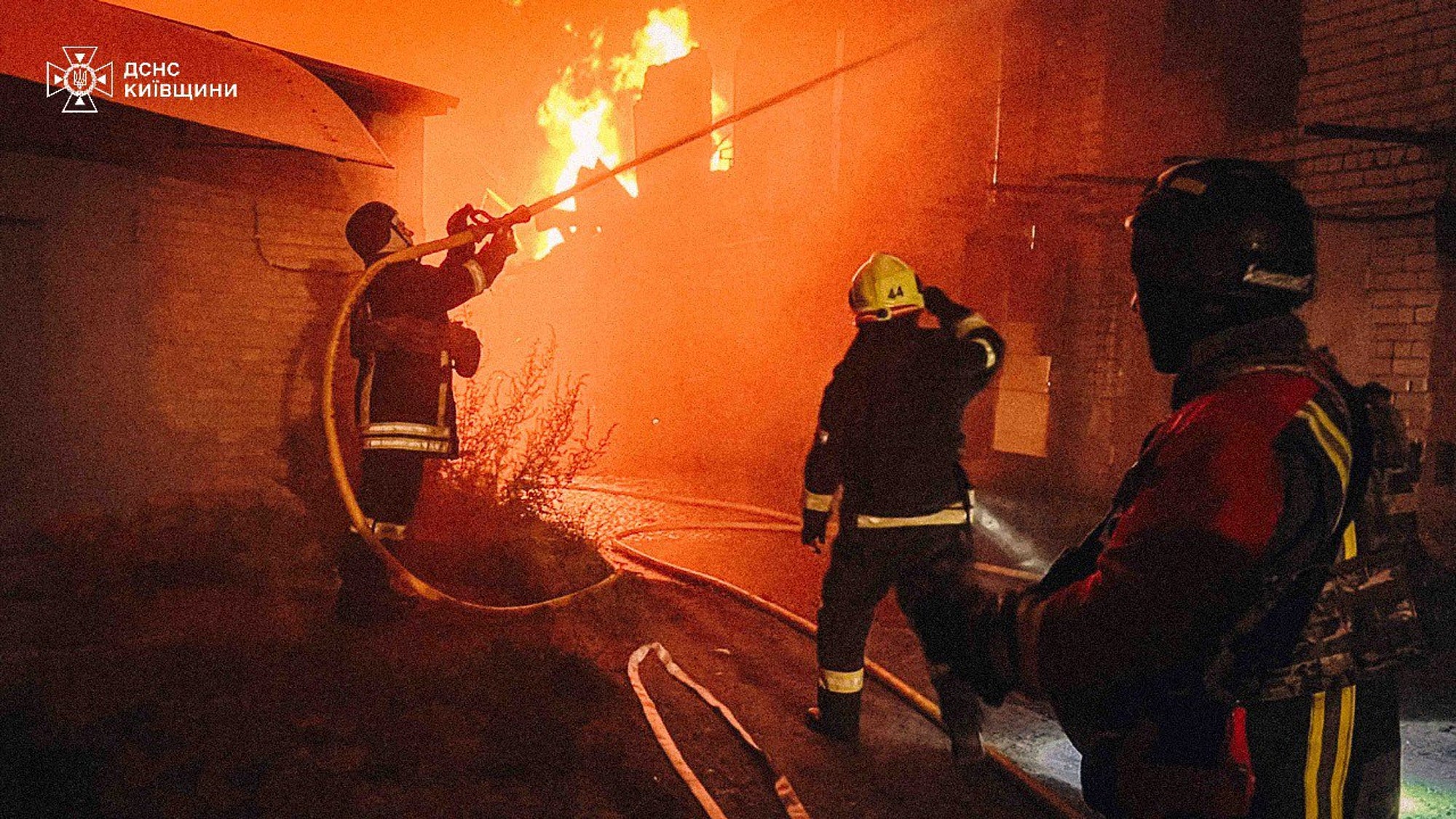 First responders work to extinguish a fire following a Russian attack in Kyiv region on 4 July