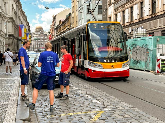 <p>Men chat next to a stopped tram during a major power outage in Prague, Czech Republic, July 4, 2025</p>