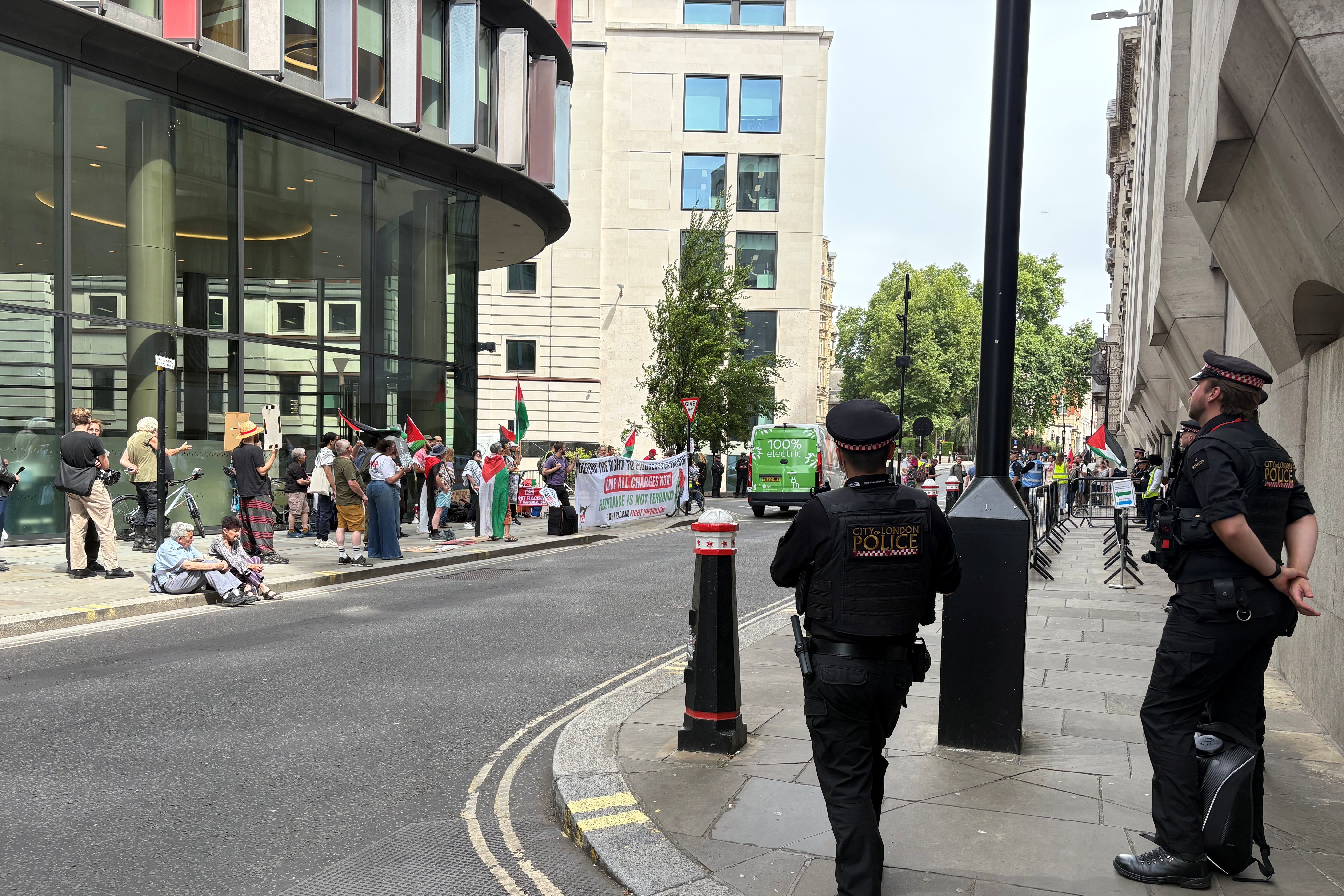 Officers from the City of London Police watch pro-Palestine protesters outside the Old Bailey, where Sarah Cotte appeared in court accused of expressing support for Hamas in a speech at a London university (PA)