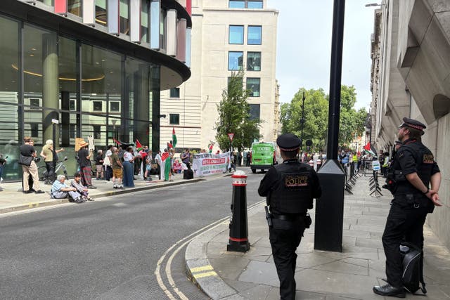 Officers from the City of London Police watch pro-Palestine protesters outside the Old Bailey, where Sarah Cotte appeared in court accused of expressing support for Hamas in a speech at a London university (PA)