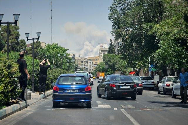 <p>Residents take pictures of smoke rising from an Israeli strike in Tehran, Iran, Monday, June 23, 2025</p>