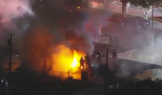 Firefighters tackle blaze after fireworks detonate in Pacoima, California. A man died and a woman was taken to hospital in critical condition following the incident Thursday