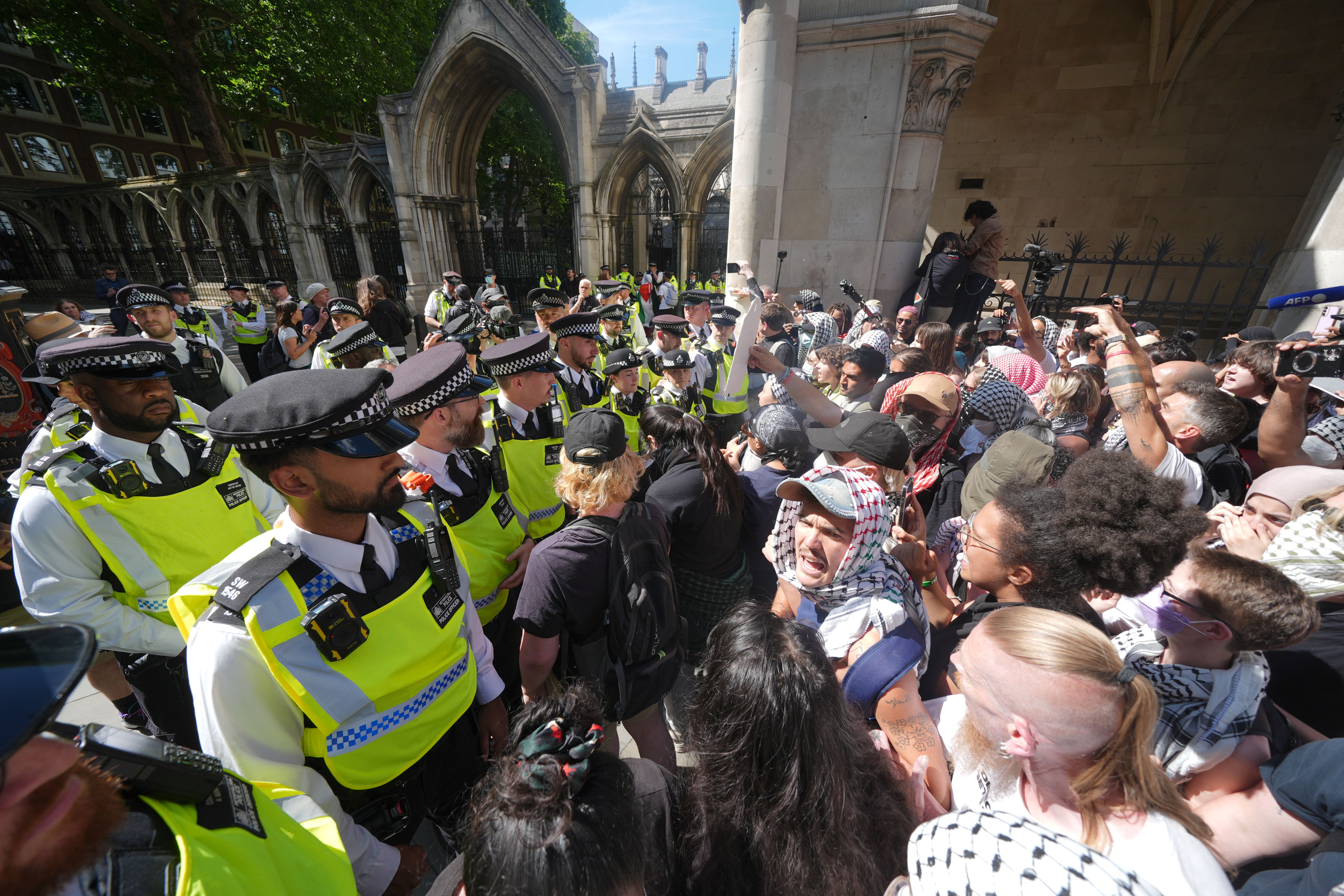 Police officers clash with protesters outside the Royal Courts of Justice on The Strand, central London, where a hearing over whether the proscribing of Palestine Action should be temporarily blocked (Lucy North/PA)