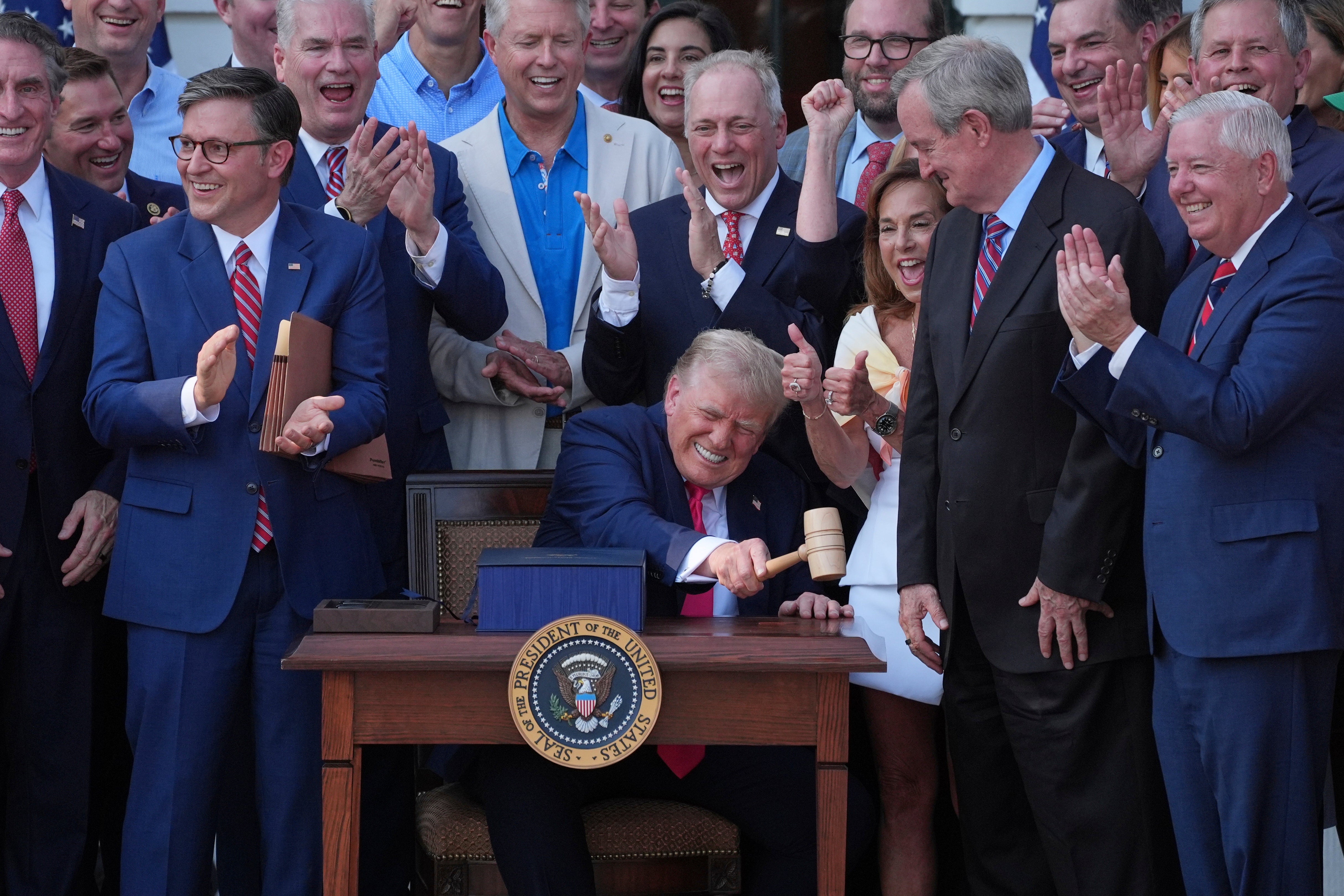 President Donald Trump bangs a gavel gifted to him by Speaker Mike Johnson after he signed the 'Big, Beautiful Bill' on Friday