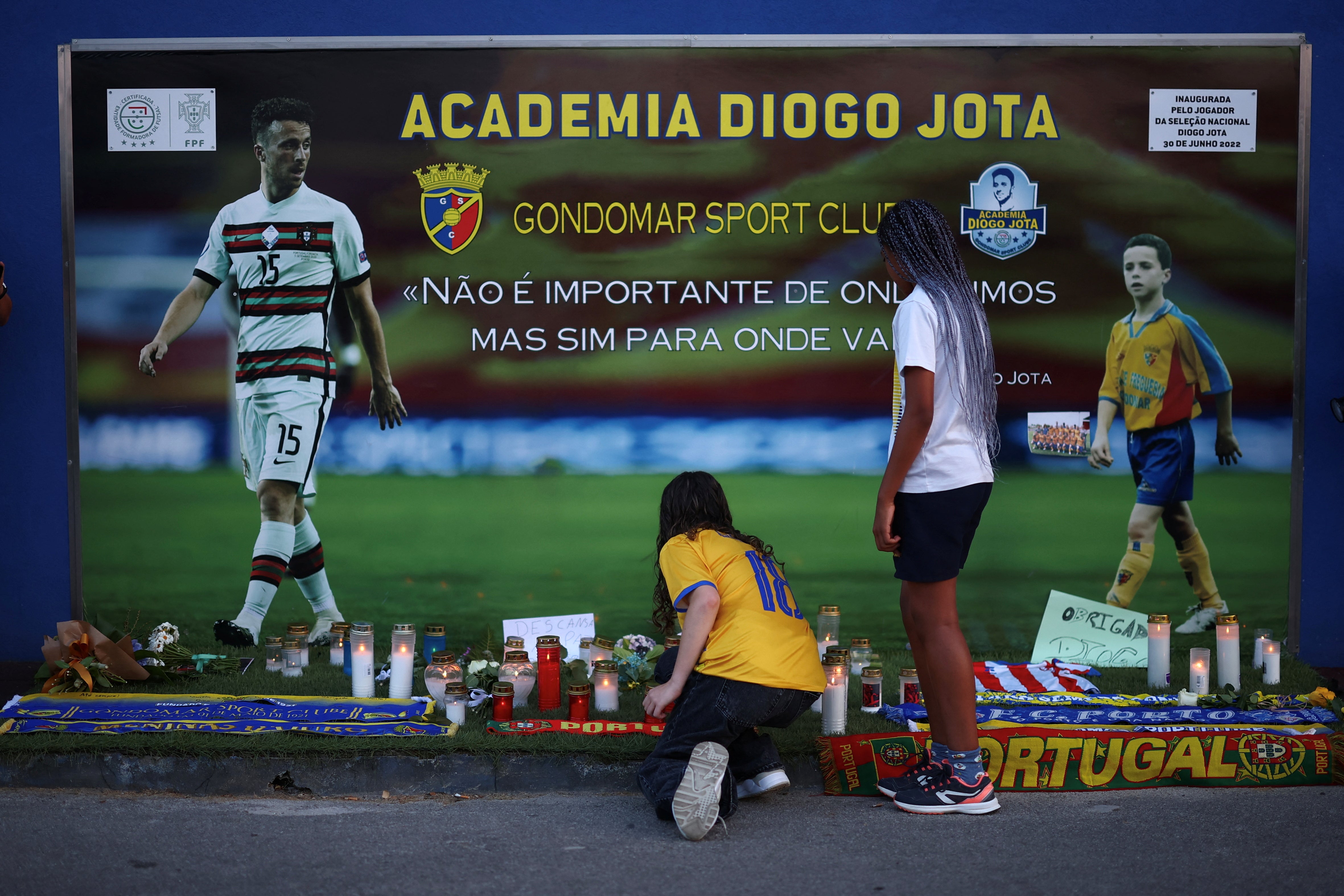 Ein Mann kniet vor der temporären Gedenkhalle des portugiesischen Fußballspieler Diogo Jota
