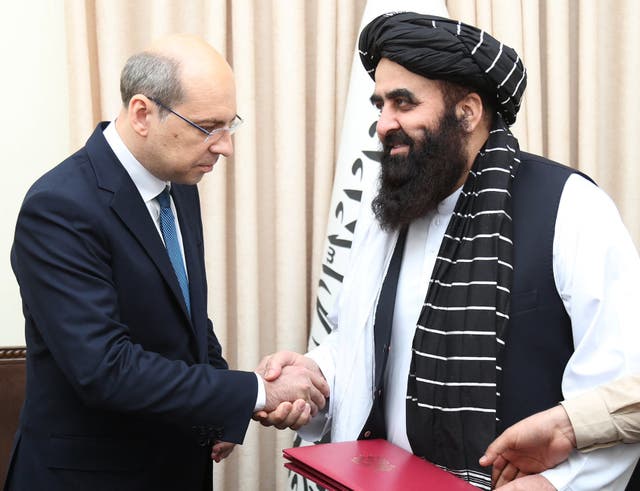 <p>Afghanistan's foreign minister Amir Khan Muttaqi (R) shaking hands with Russia's ambassador to Afghanistan Dmitry Zhirnov during their meeting at the foreign ministry in Kabul</p>