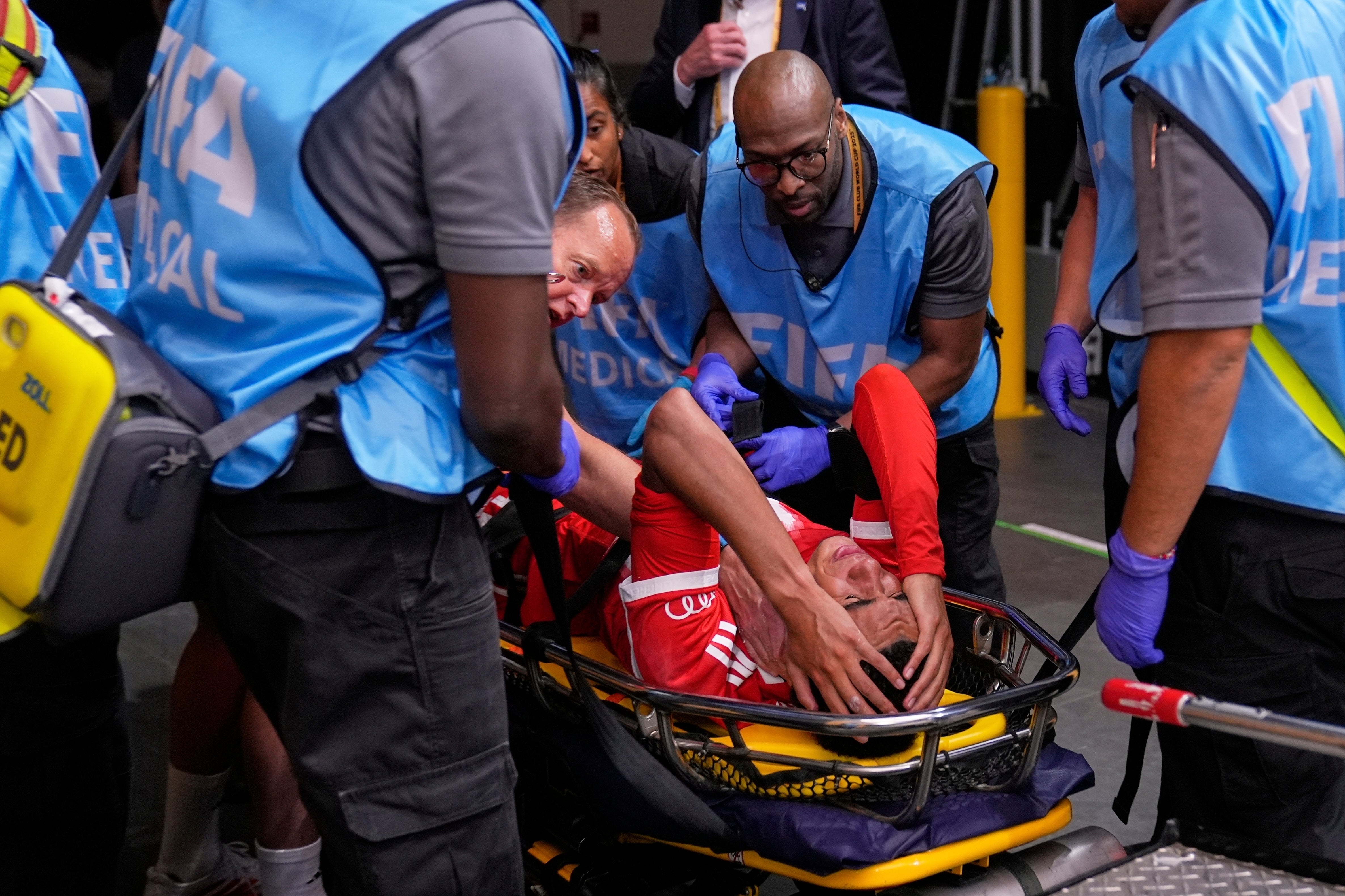 Jamal Musiala holds his face in pain as he is carried away
